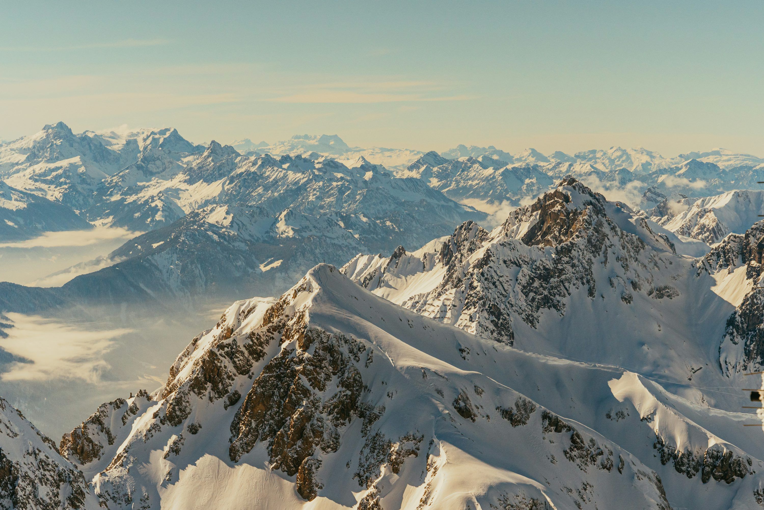 3000x2002 A mountain range covered in snow with mountains in the background photo