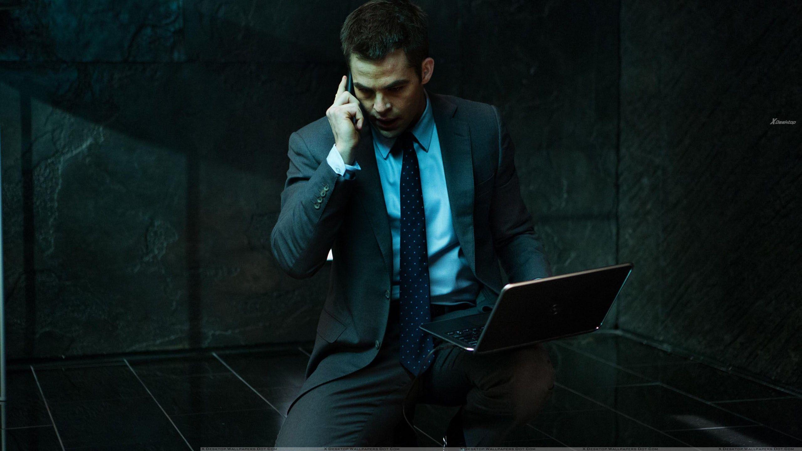 2560x1440 Chris Pine Sitting On Floor In Grey Suit Laptop In Hand Wallpaper