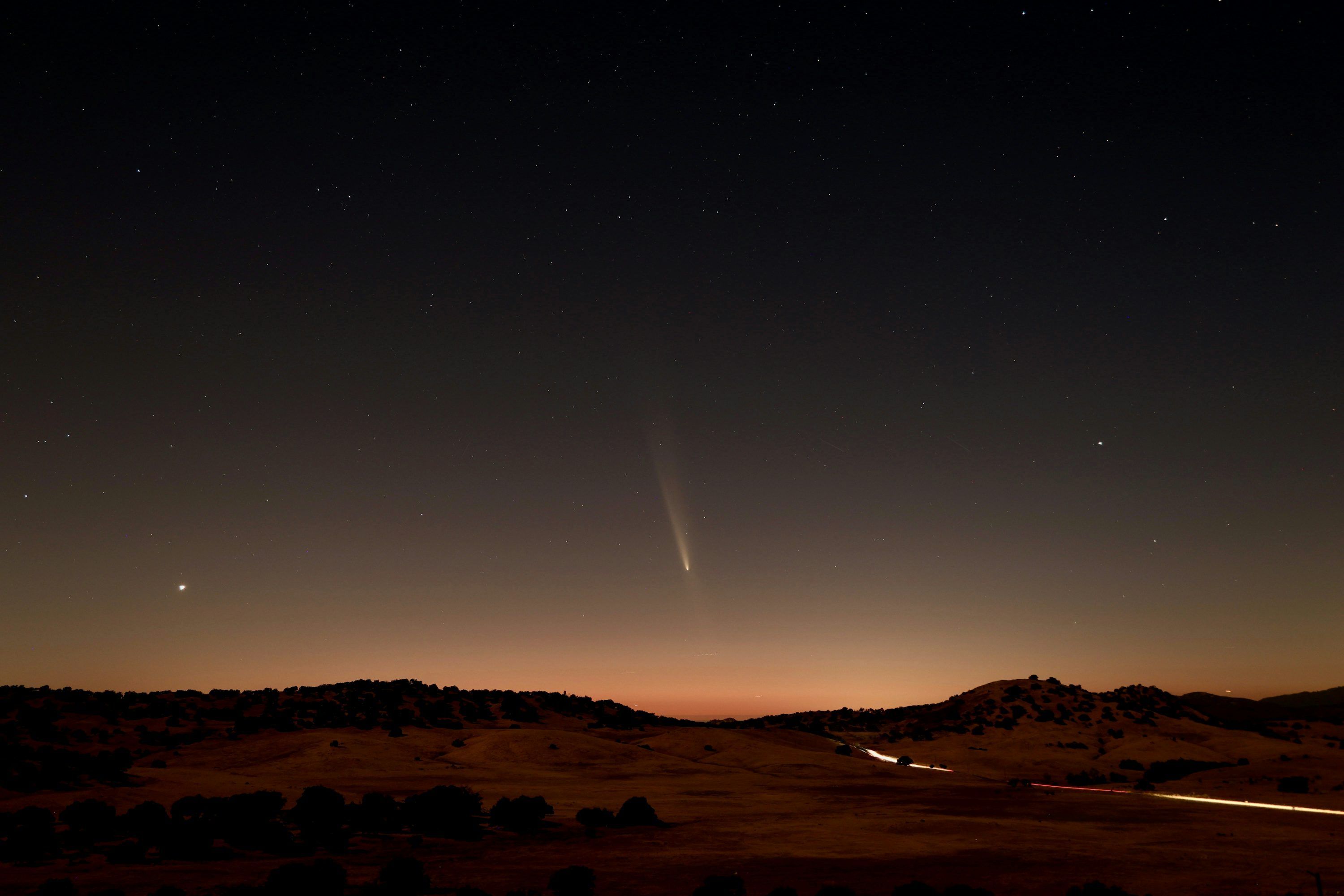 3000x2000 A view of the night sky with a bright star in the distance photo
