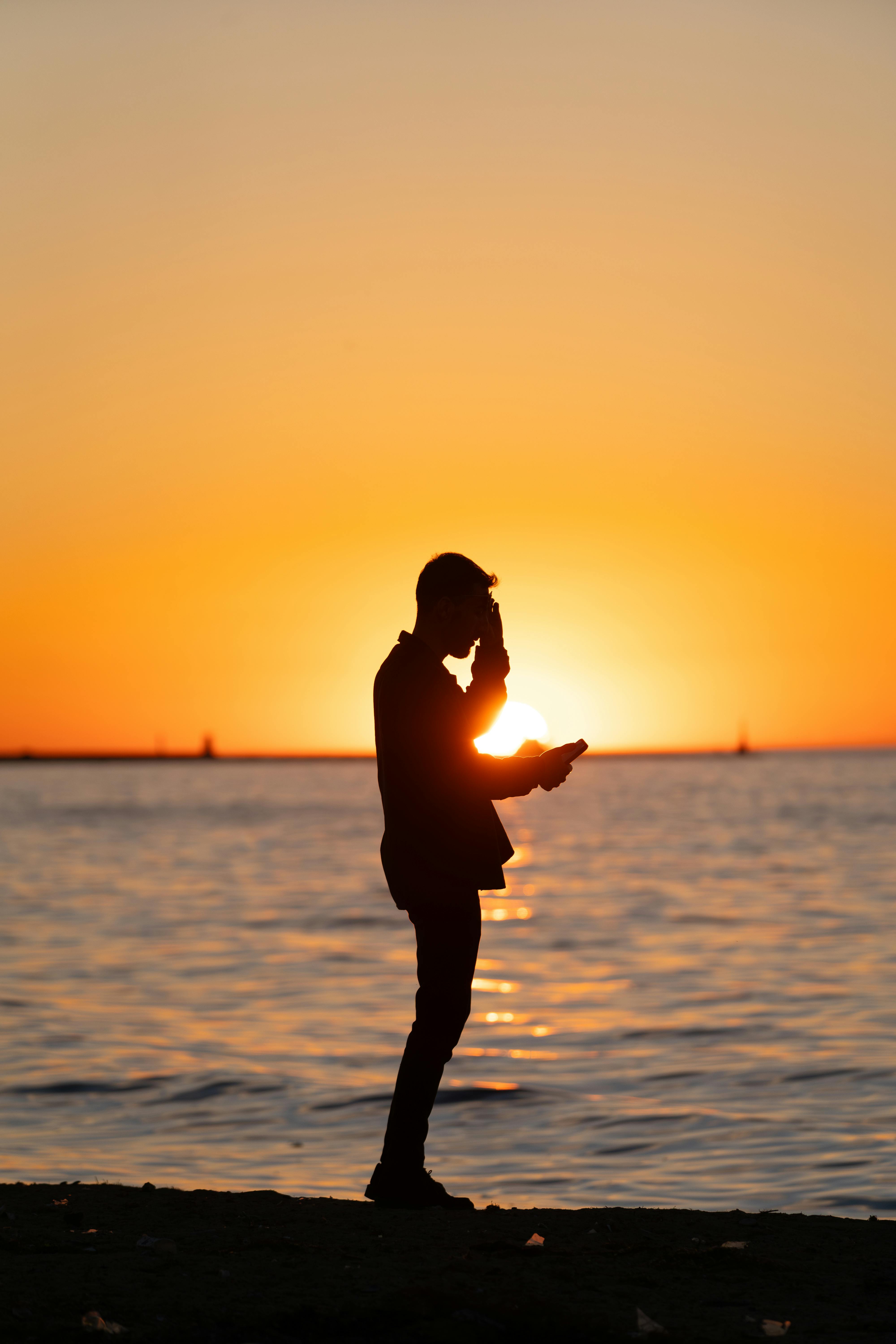 4000x6000 Silhouette of a Person at Sunset by the Water · Free