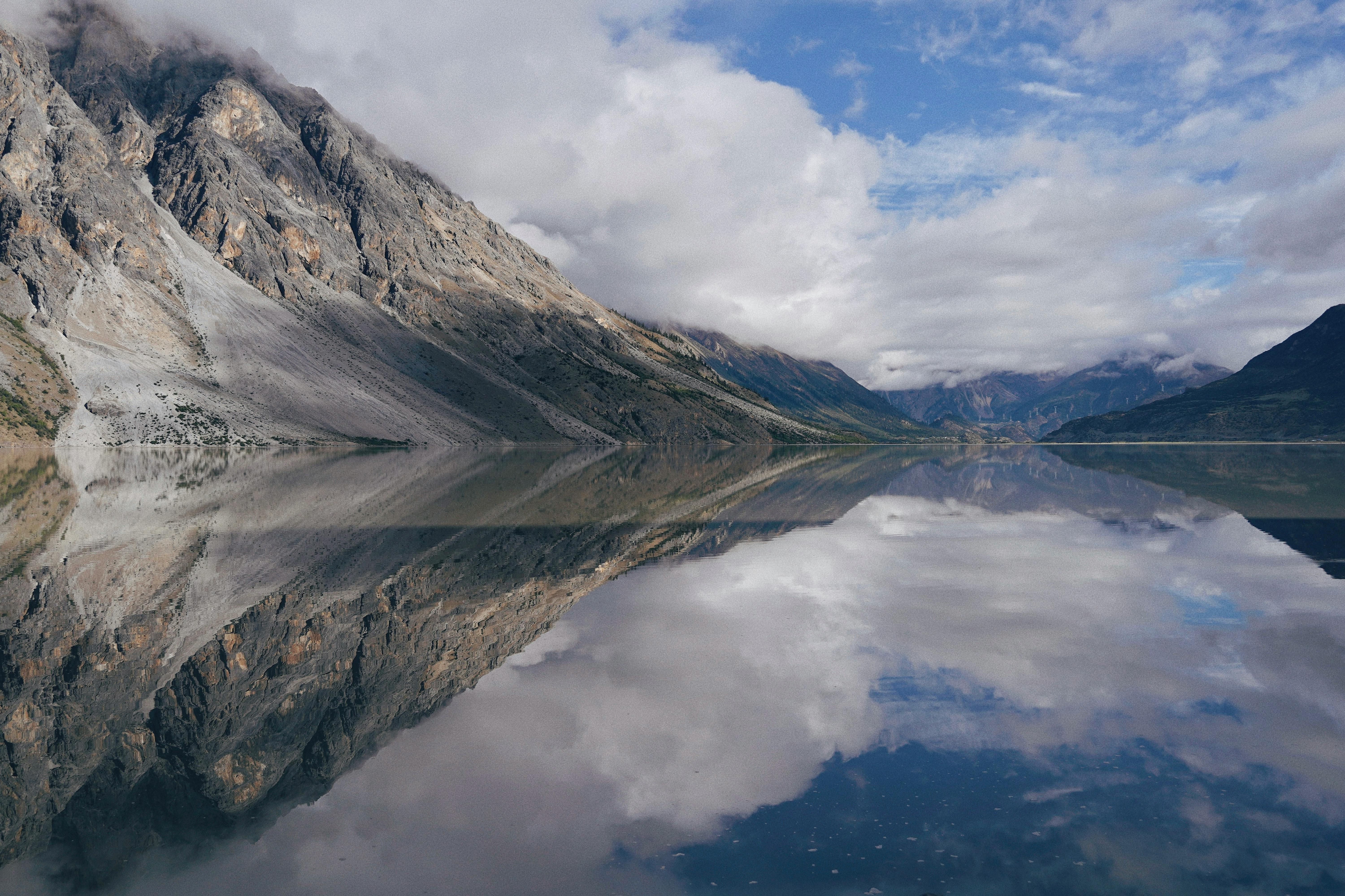 6000x4000 Rocky Mountainside Reflected in the Water of a Placid Lake · Free
