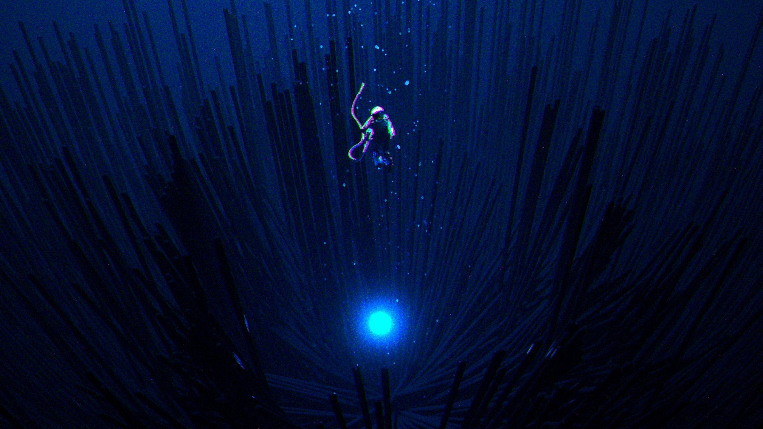 2560x1440 Download wallpaper 2560x1440 scuba diver, levitation, dark, shine
