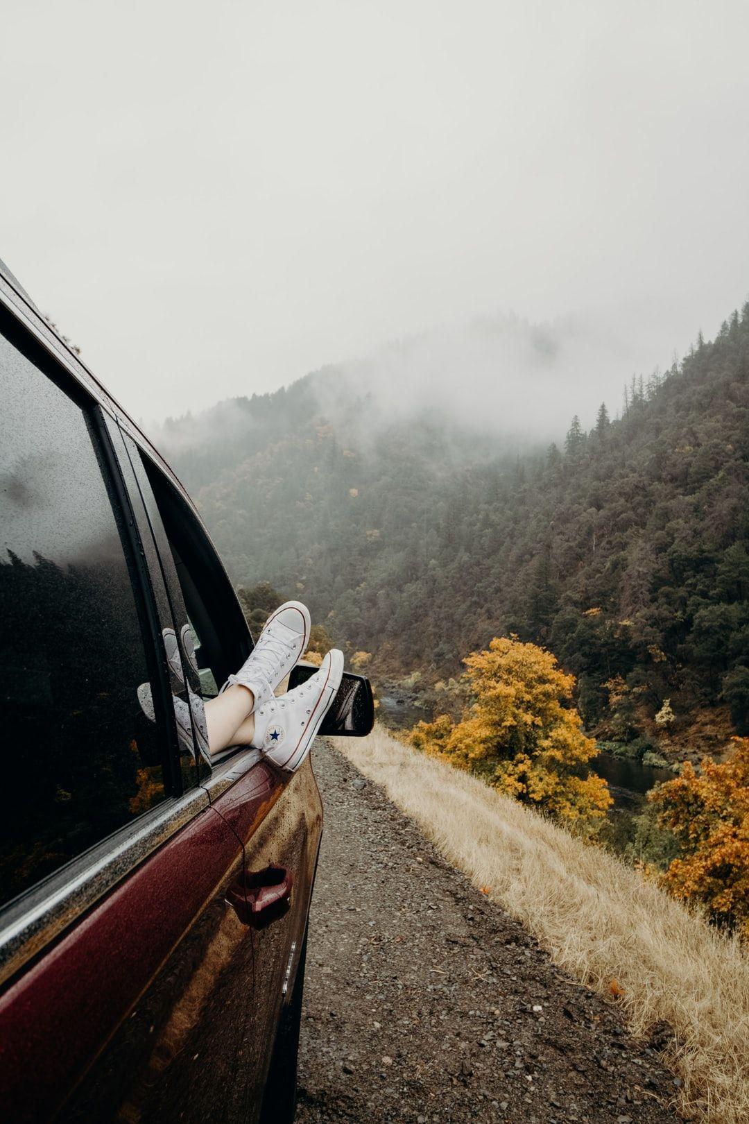 1080x1620 person's feet wearing white Converse sneakers on car door photo