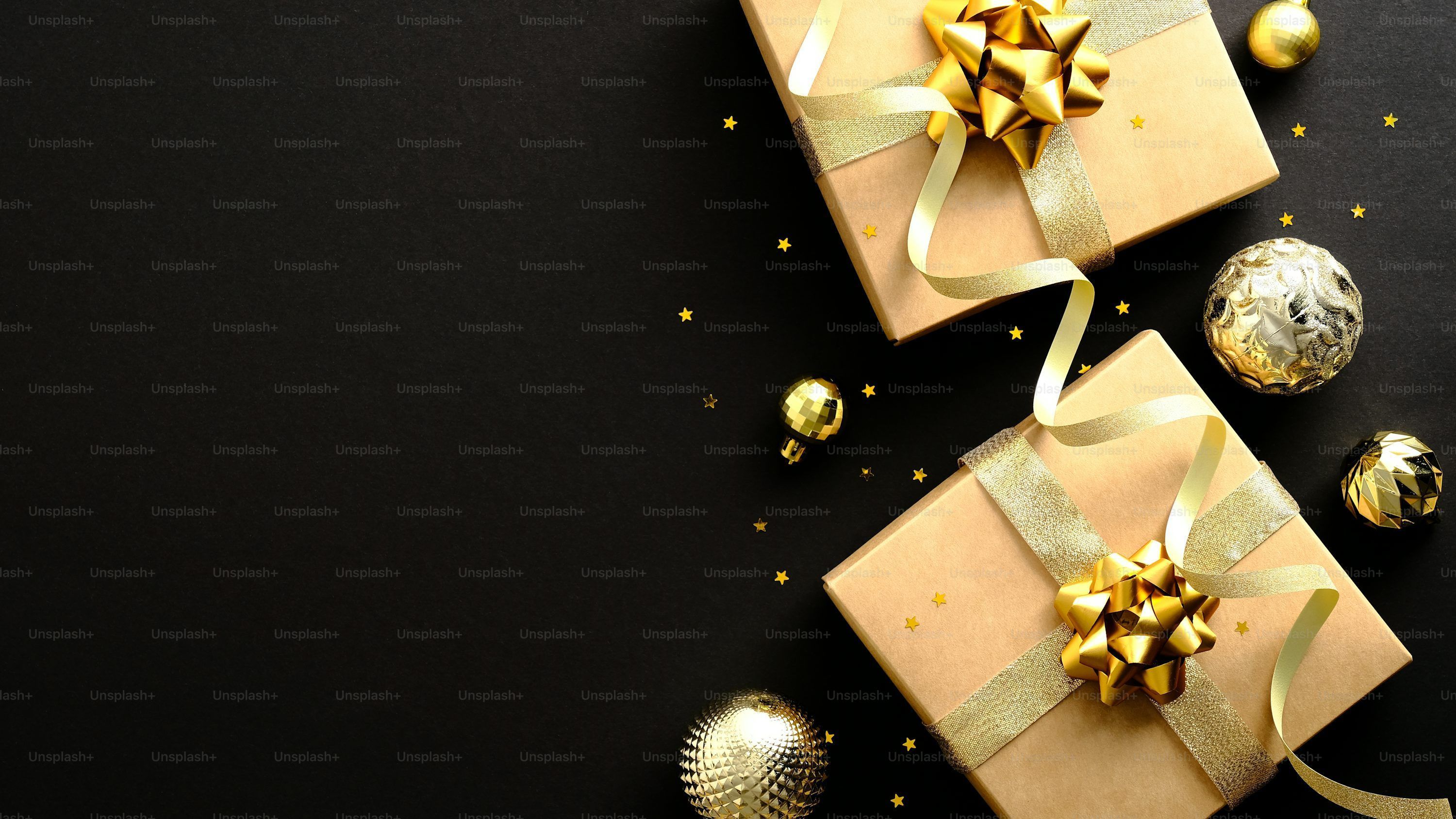 3000x1688 Luxury Christmas banner design. Flat lay gift boxes with golden ribbon, gold baubles, confetti on dark black background photo