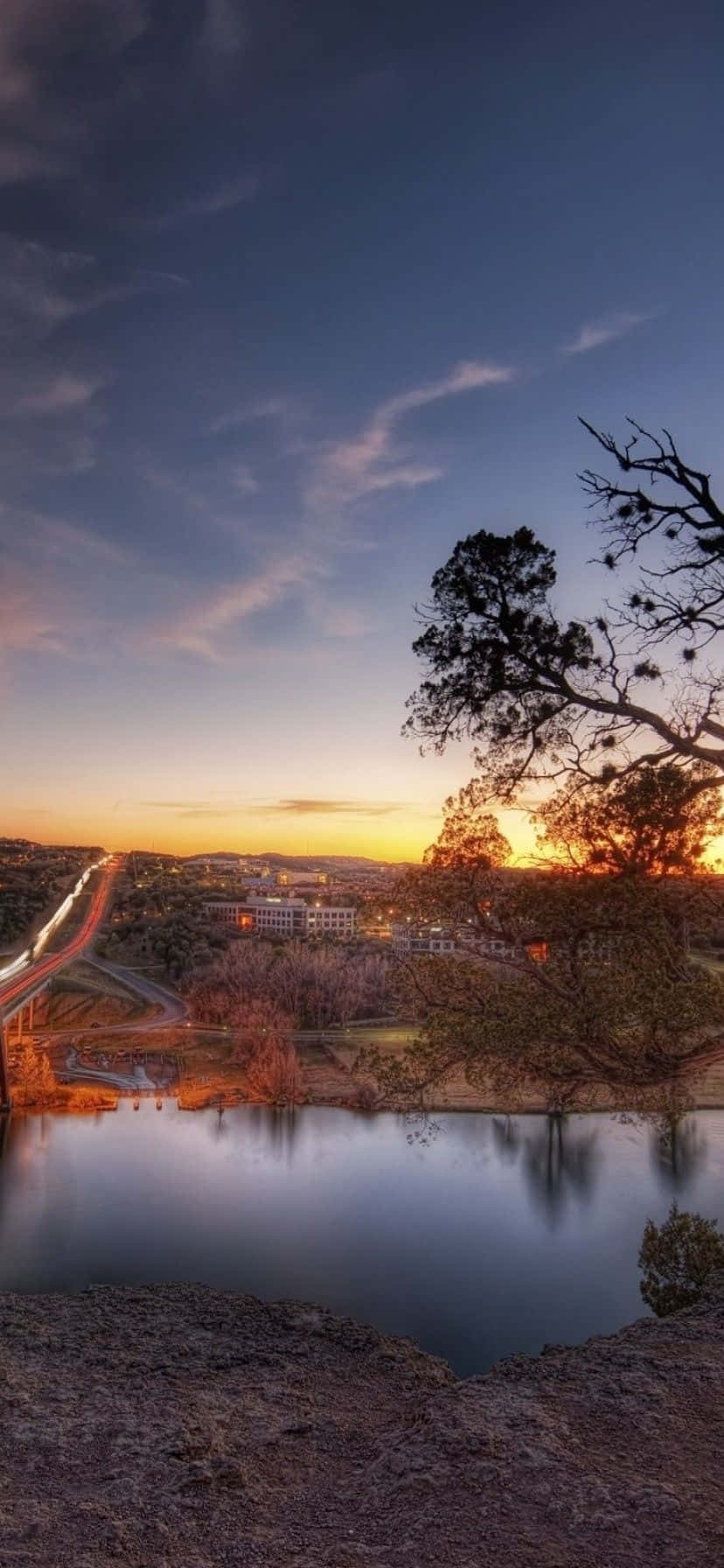 828x1792 Download A Bridge Over A River At Sunset Wallpaper