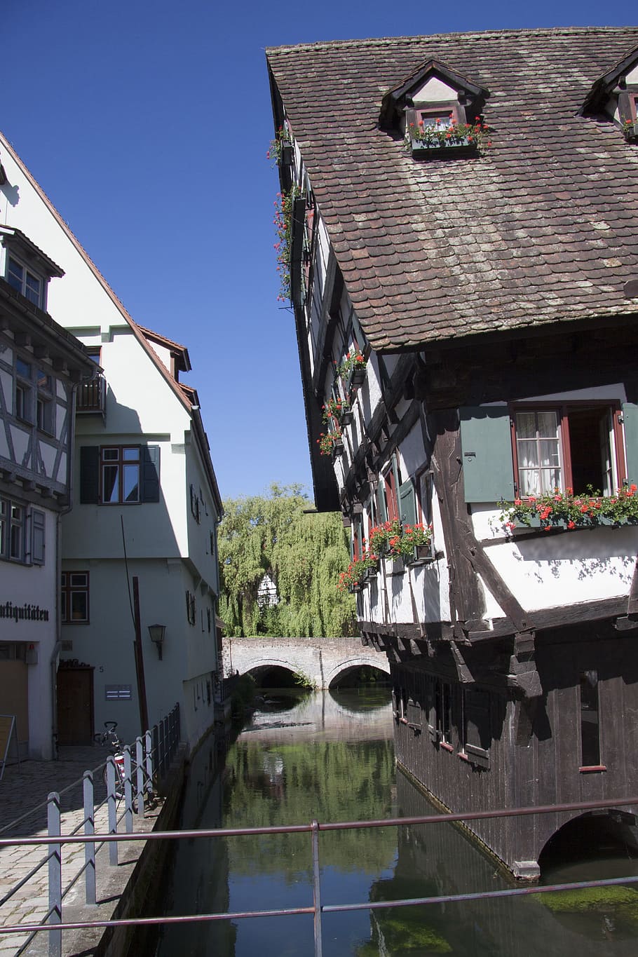910x1365 HD wallpaper: leaning brown and white house near to body of water, ulm, crooked house
