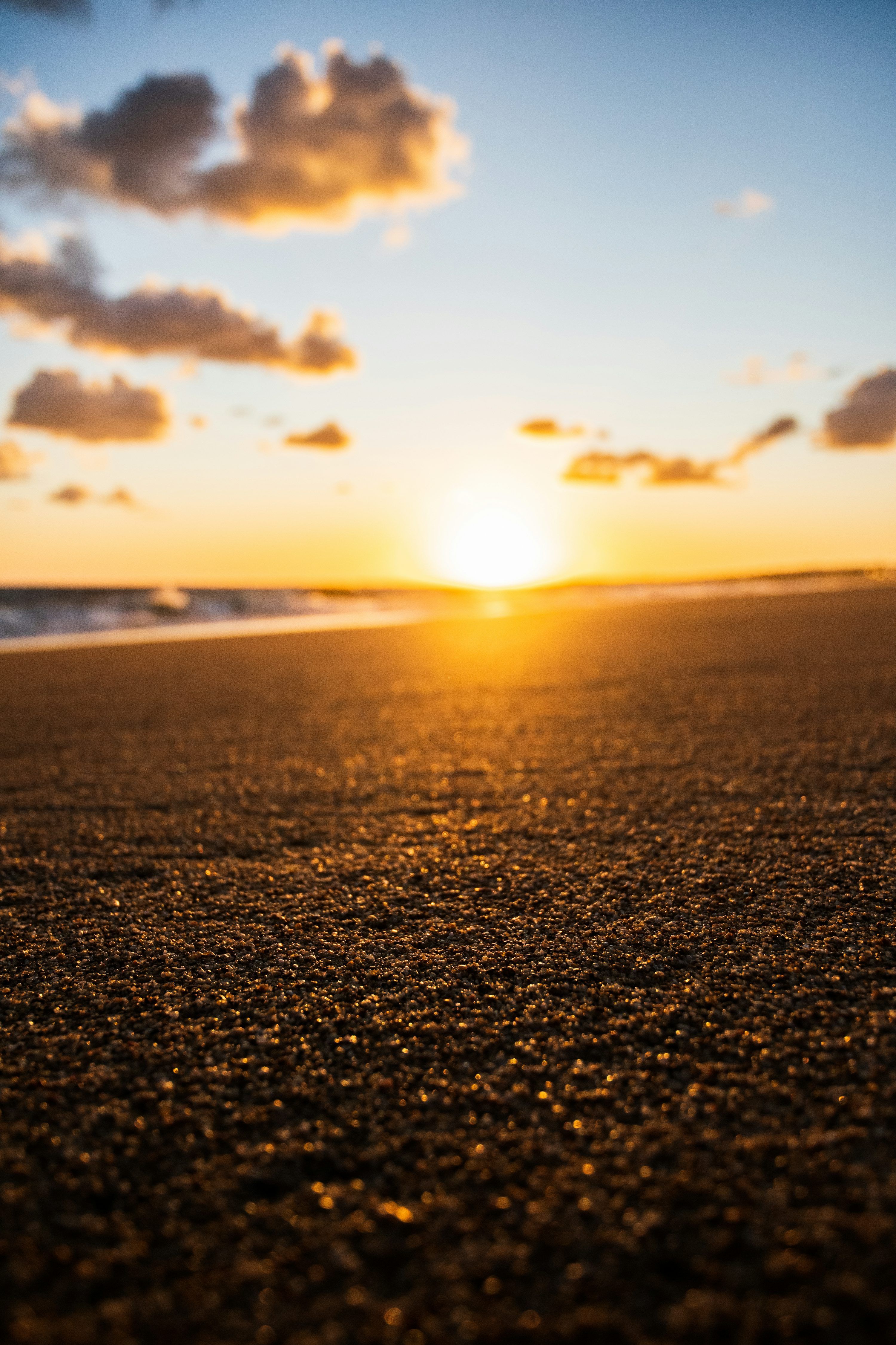 3000x4500 The sun is setting on the beach with the ocean in the background photo