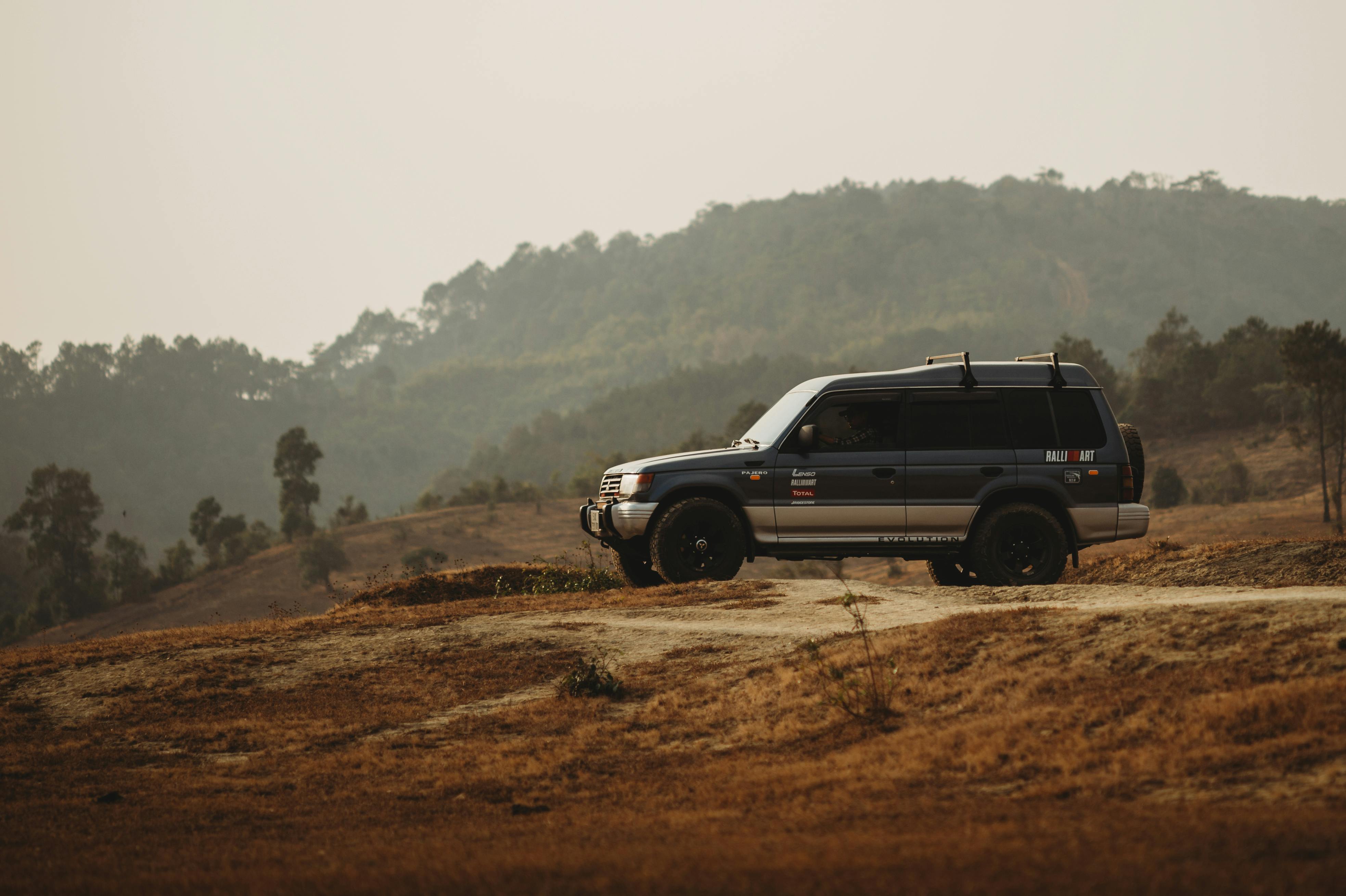 3933x2618 View of a Mitsubishi Pajero Driving on a Dirt Road · Free