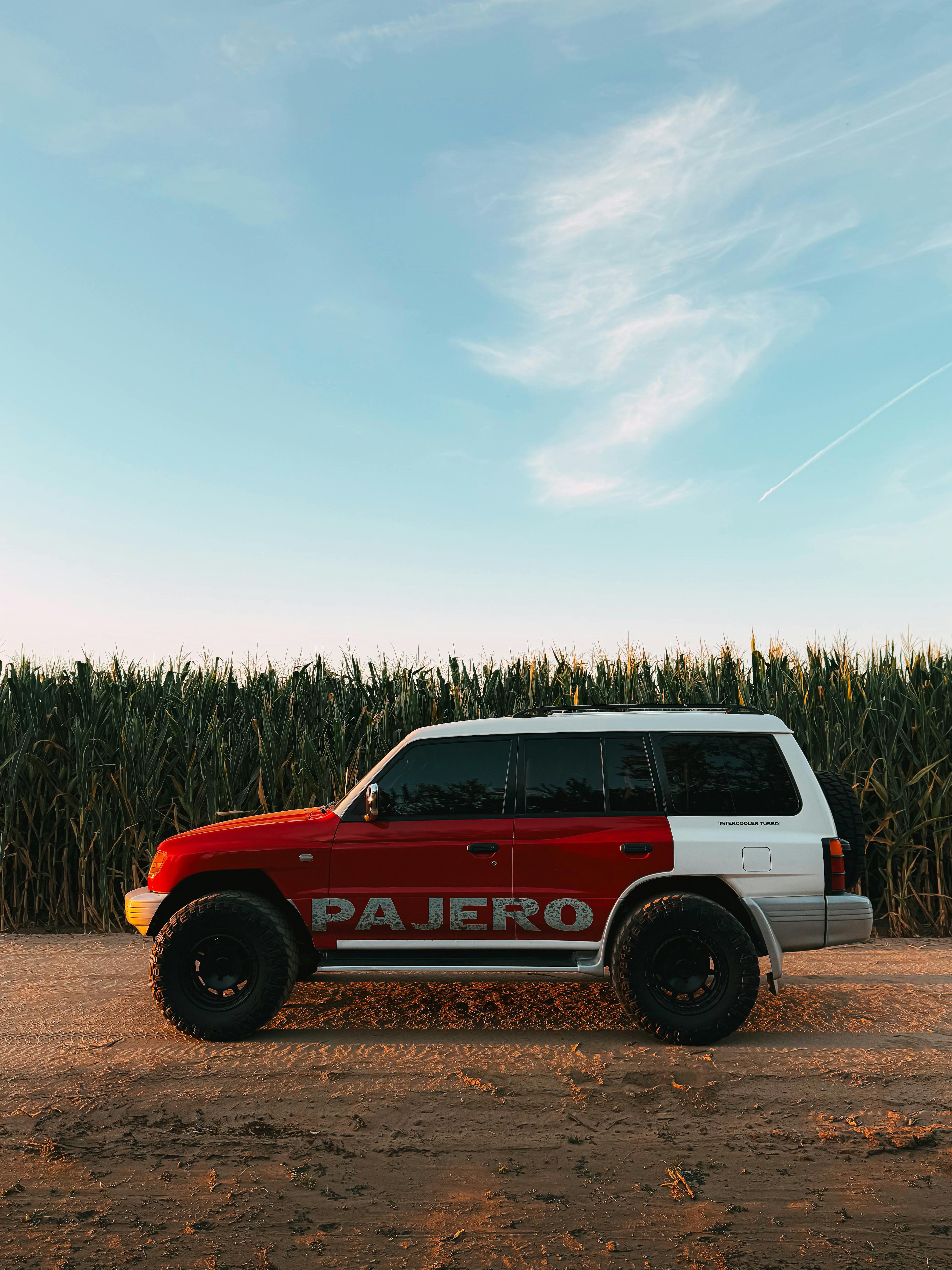 4151x5535 Red and White Pajero 4x4 Parked by Cornfield at Dusk · Free
