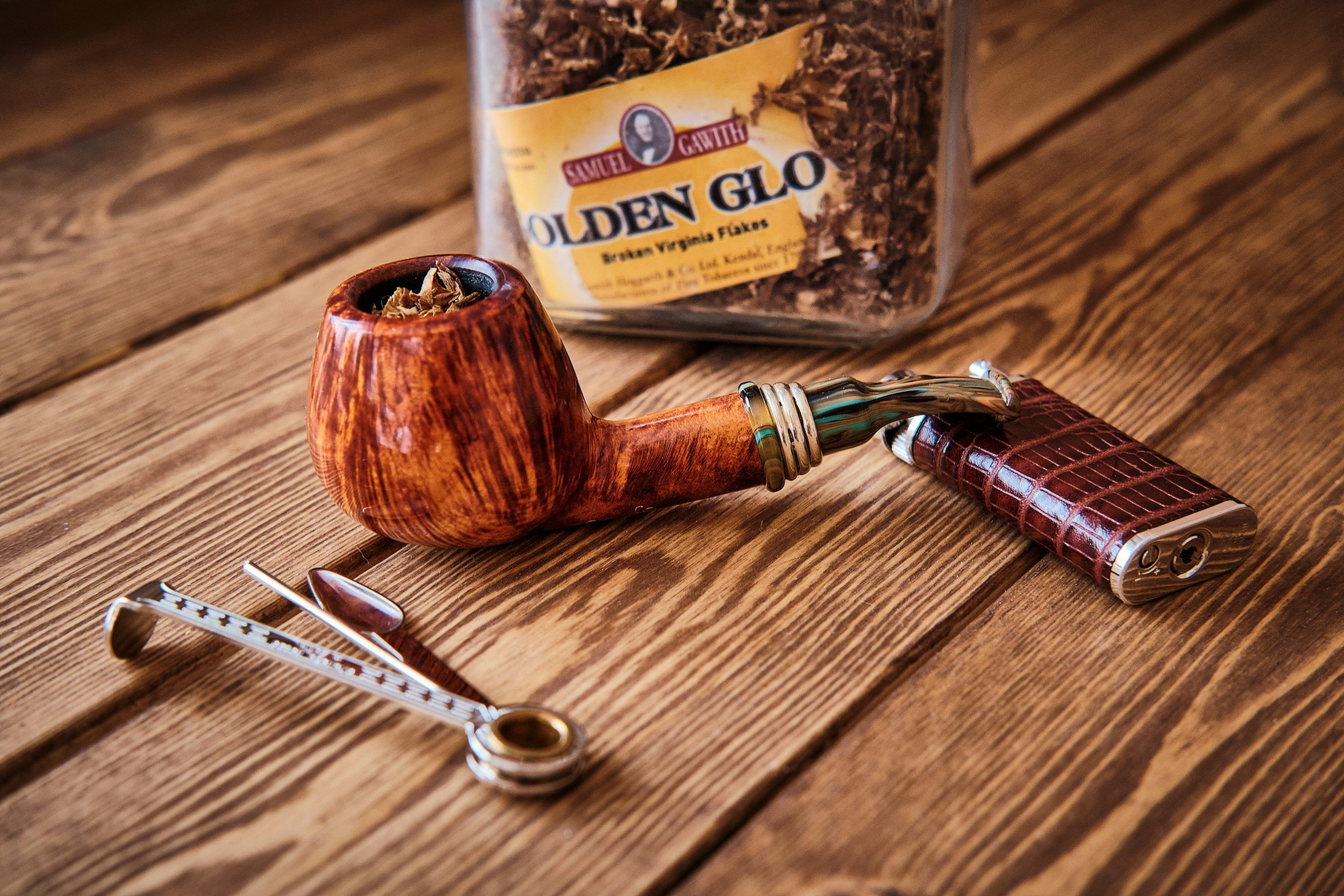 3000x2000 Brown wooden smoking pipe beside silver scissors photo