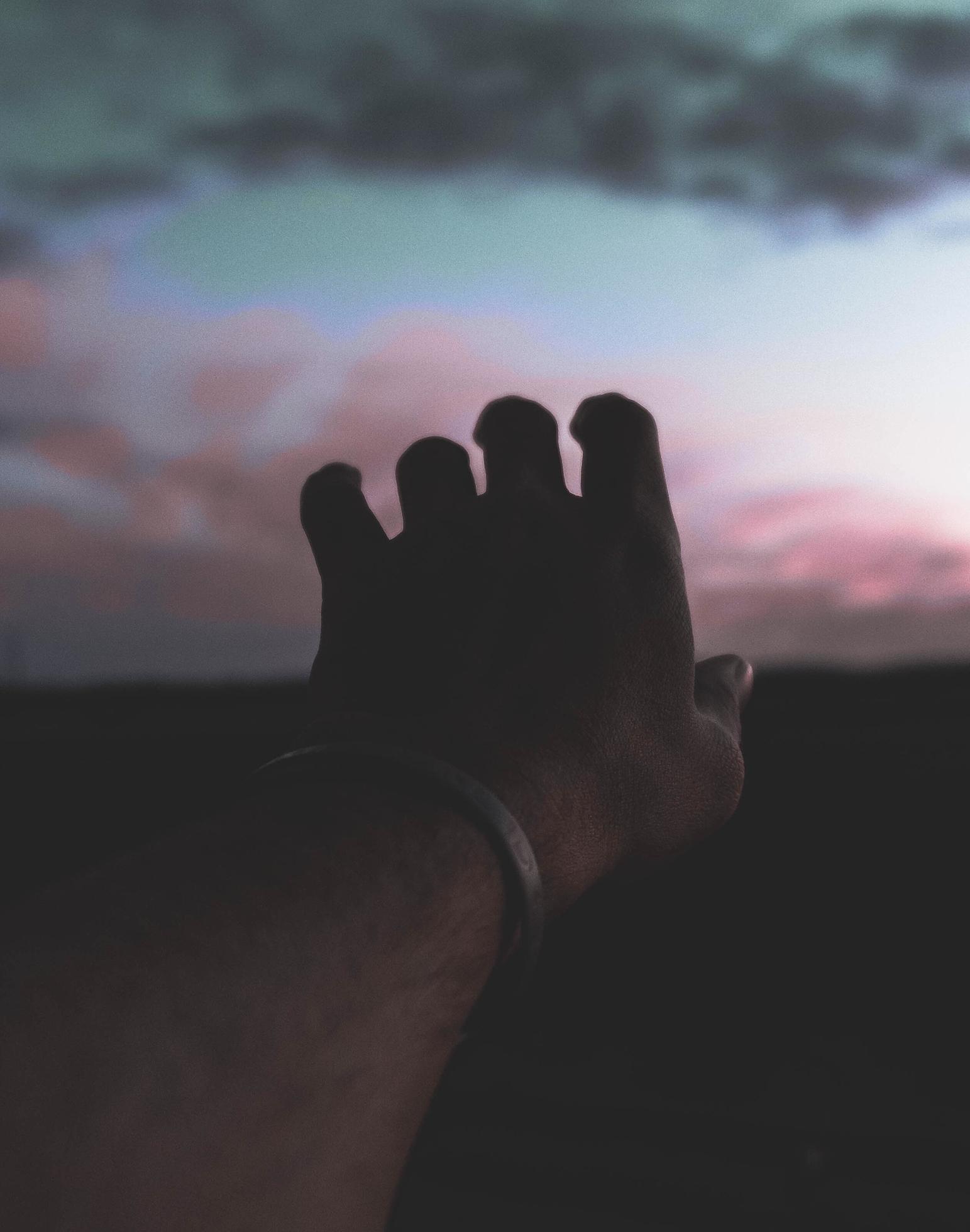 1543x1960 Hand reaching out to sunset in natural low light