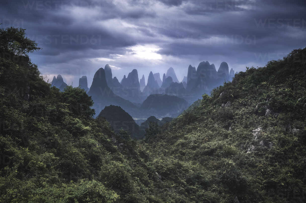 1232x816 Yangshuo mountains with dark clouds framed by hills, Yangshuo, Guangxi, China, Asia