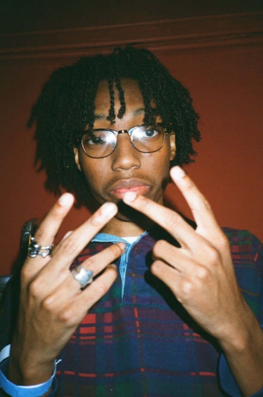 900x1358 Download A Man With Glasses And Dreadlocks Making A Finger Gesture Wallpaper
