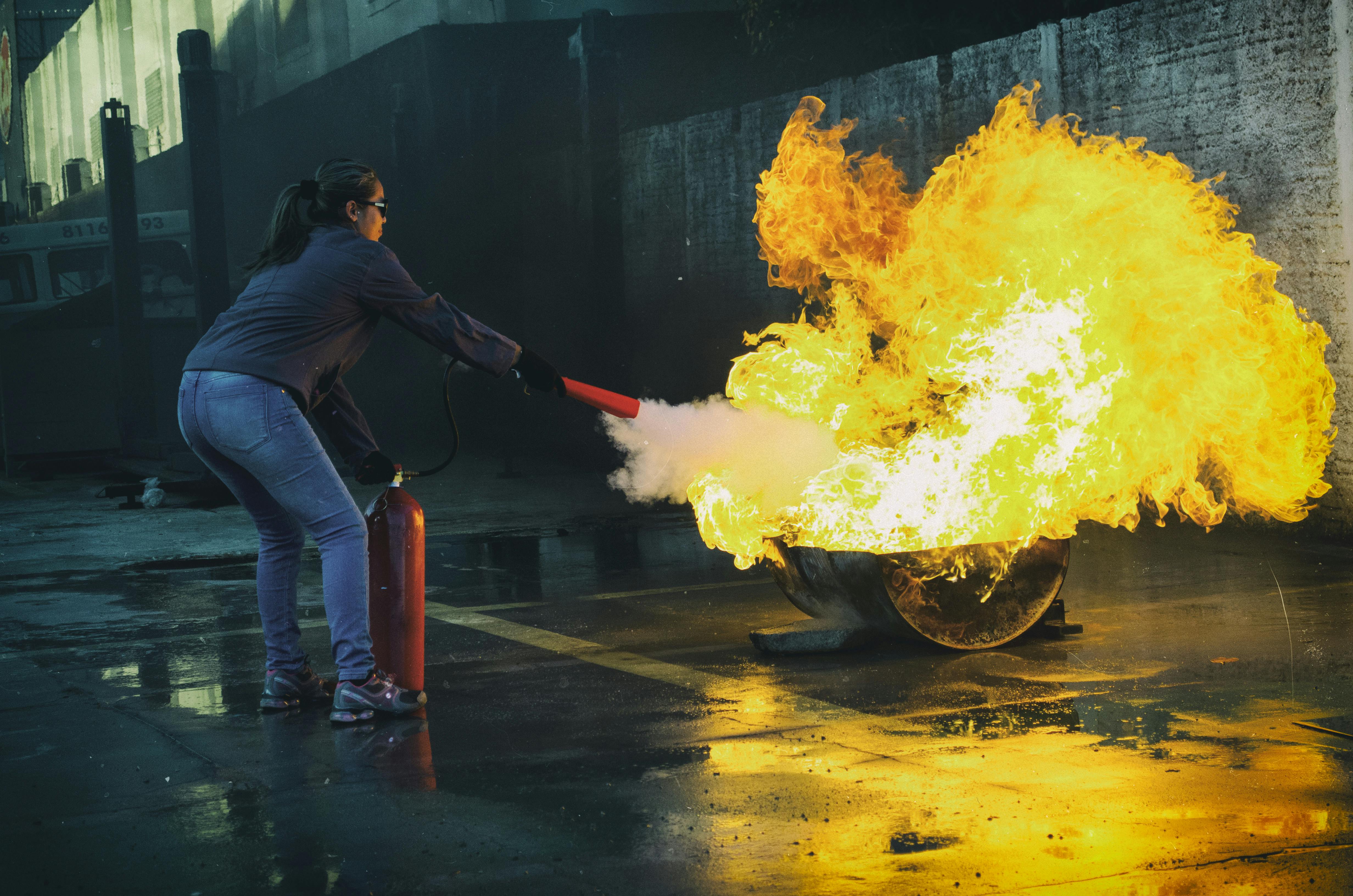 4928x3264 Woman using Fire Extinguisher to Eliminate Fire · Free