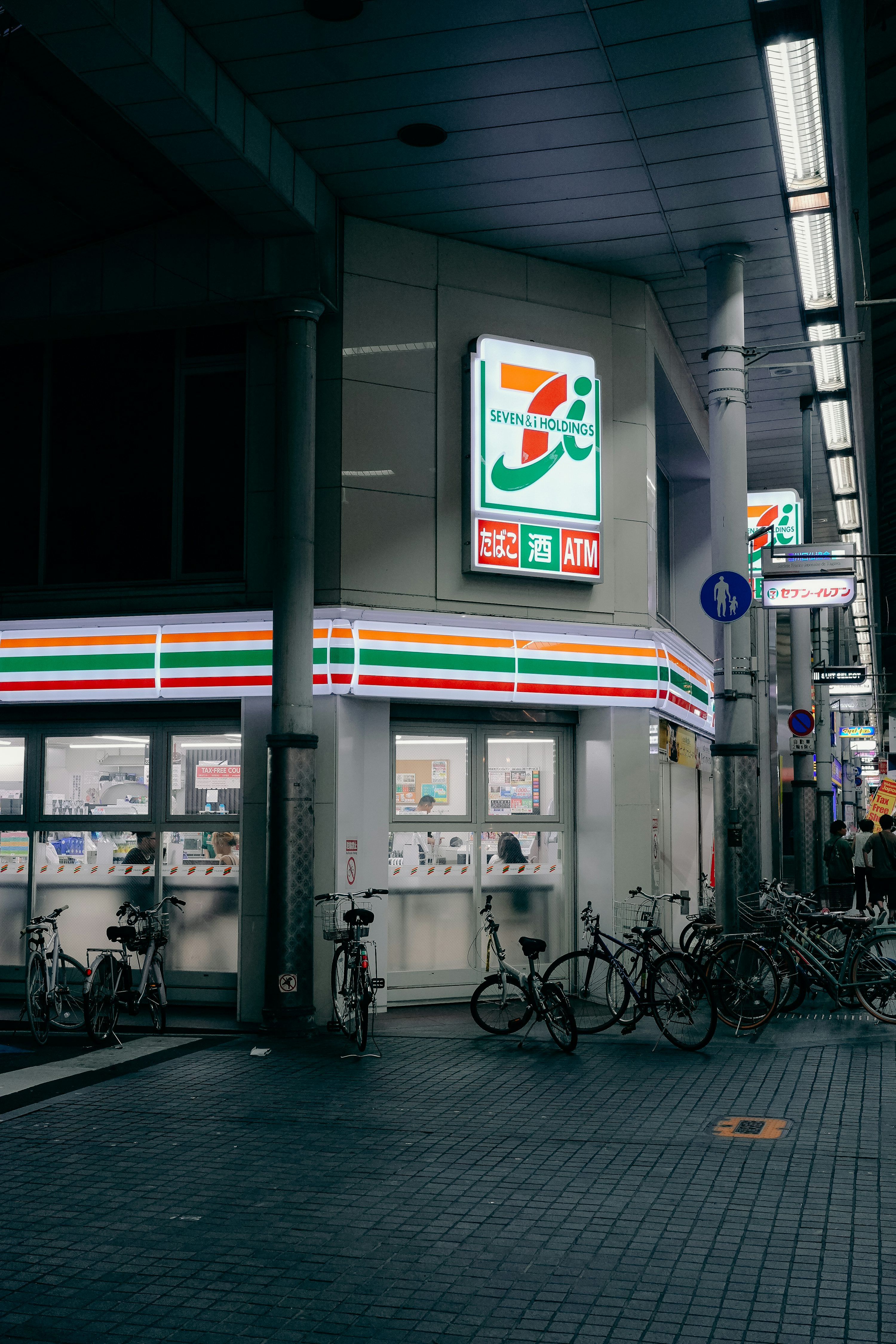 3000x4500 A seven and holdings sign lit up at night photo