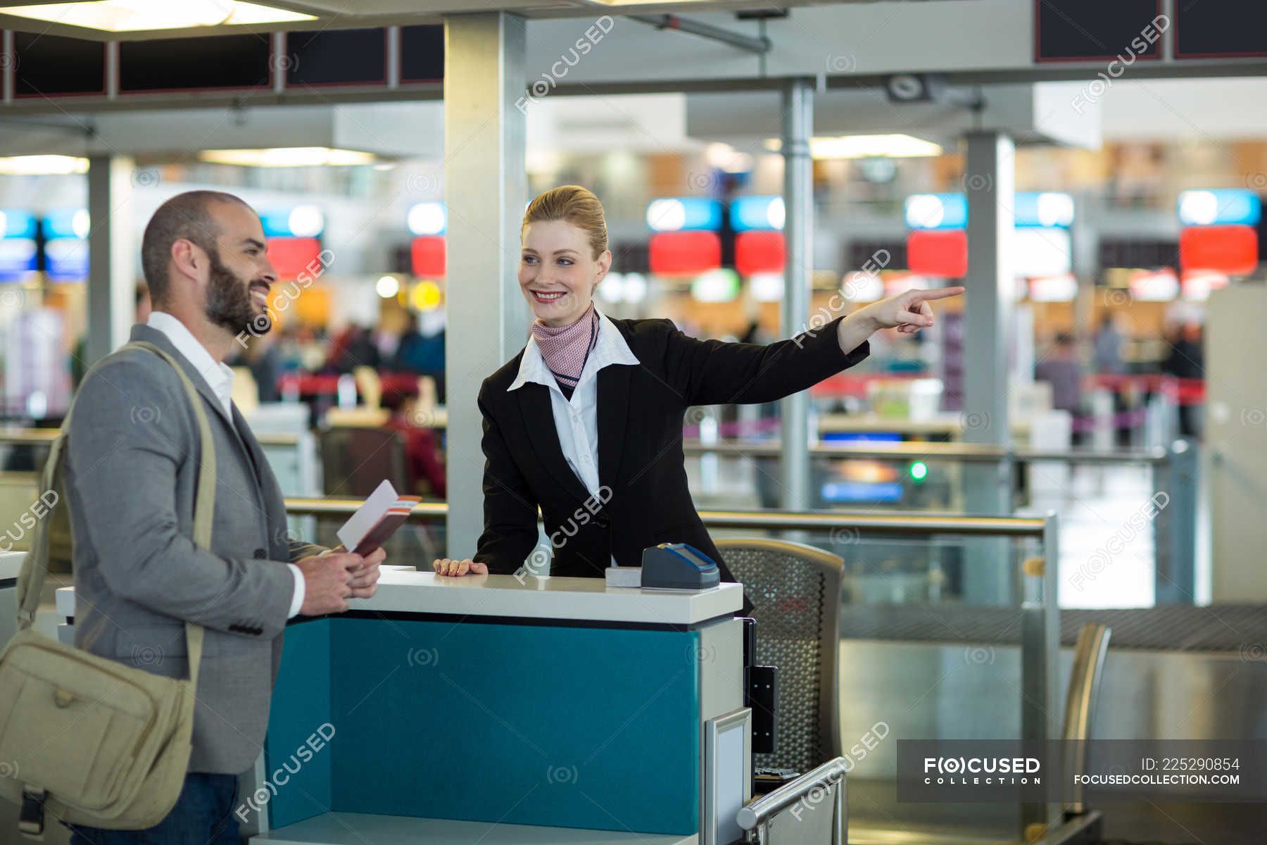 1800x1200 Airline Check In Attendant Showing Direction To Commuter At Check In Counter In Airport Terminal