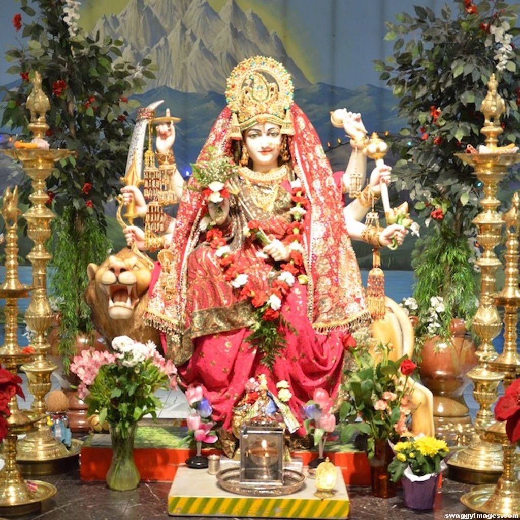 1024x1024 Download Divine Vaishno Devi Statue Adorned with Fresh Flowers Wallpaper