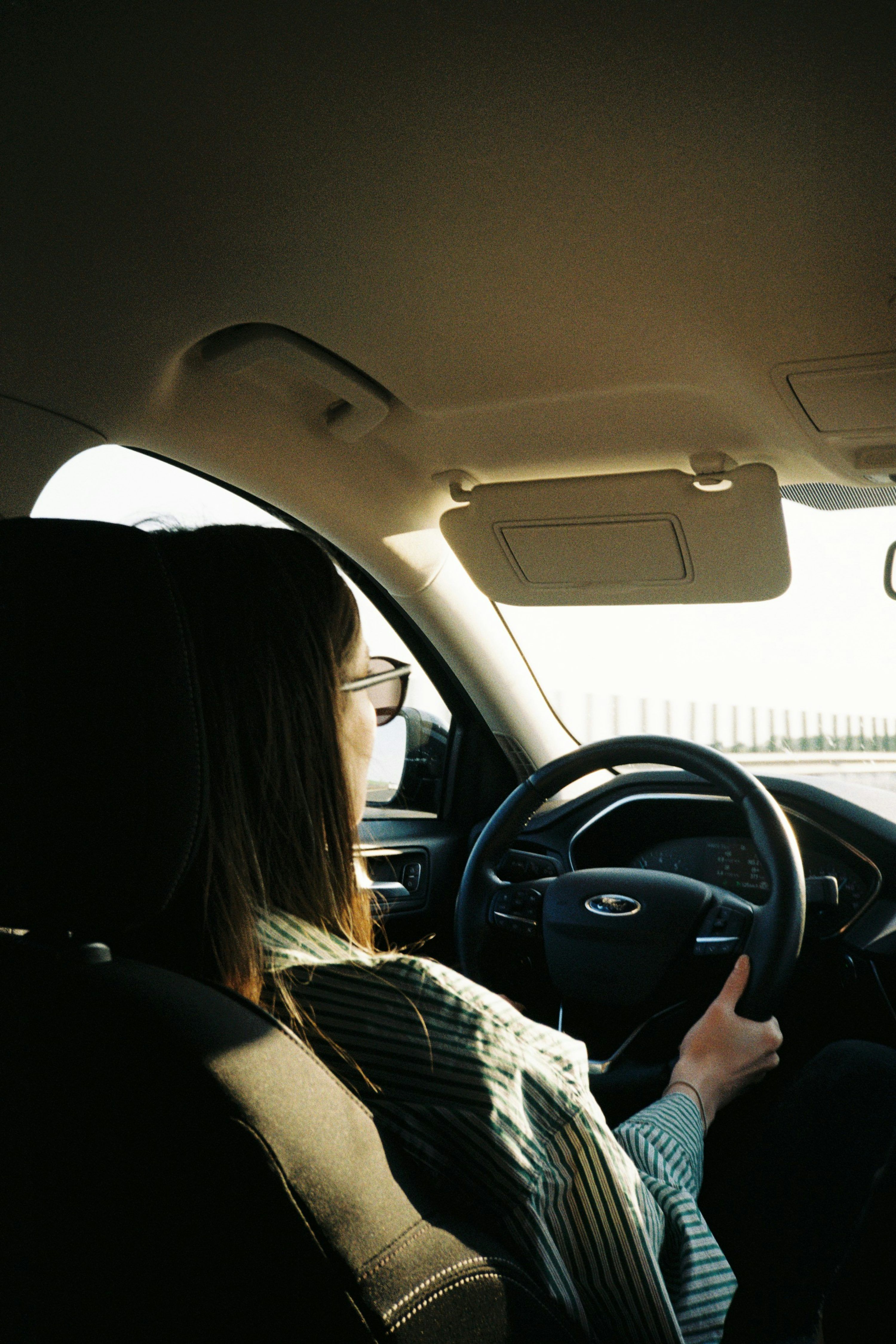 3000x4499 A woman driving a car on a sunny day photo
