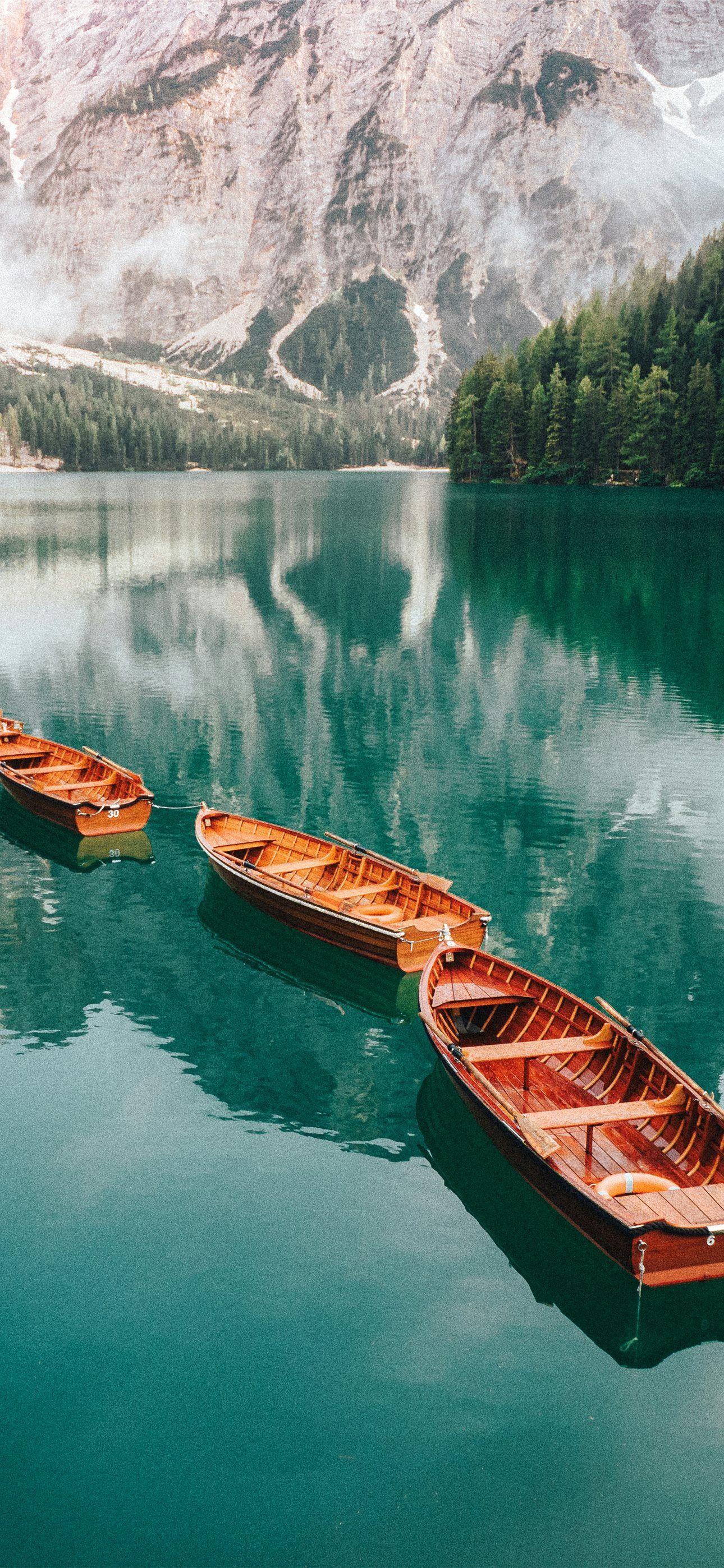 1290x2796 A group of boats floating on top of a lake iPhone Wallpaper Free Download