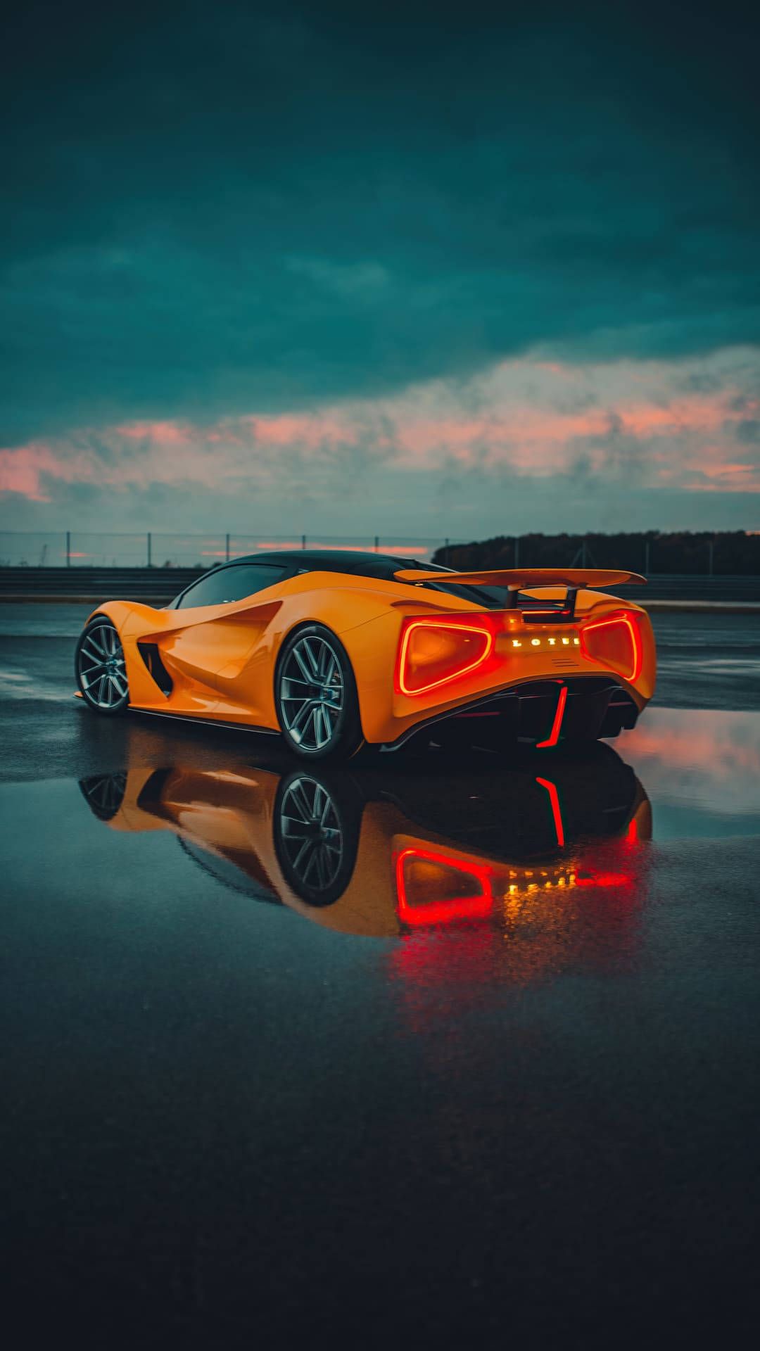 1080x1920 Download A Futuristic Orange Car Sitting On A Wet Surface Wallpaper