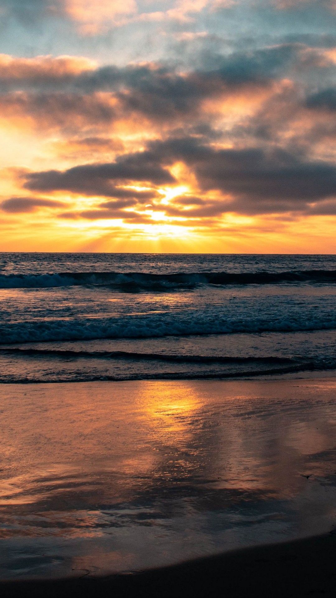 1080x1920 Beautiful Ocean View Sea Waves Beach Sand Under Black Clouds Blue Sky During Sunset 4K HD Nature Wallpaper