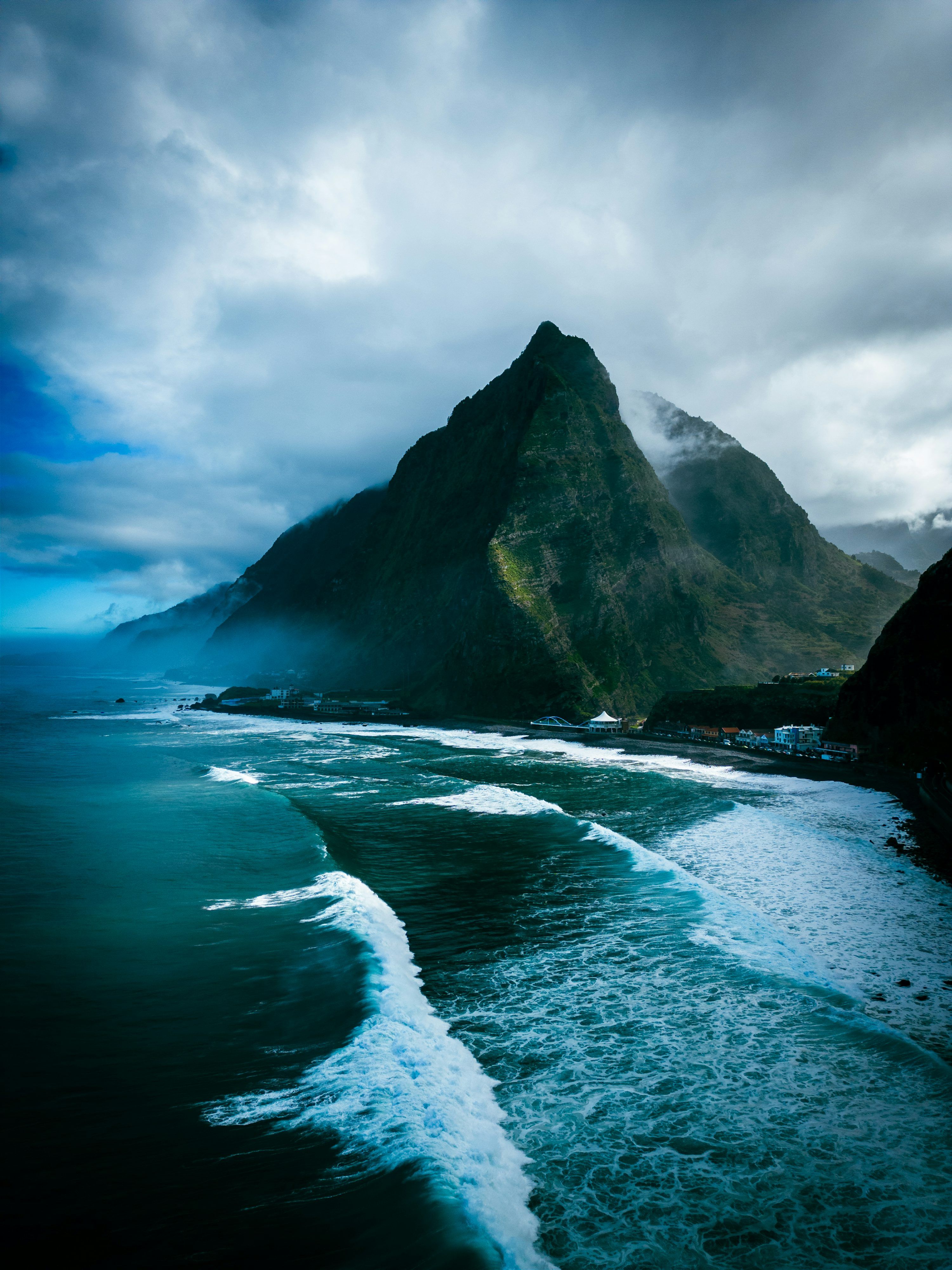3000x4000 A view of the ocean with a mountain in the background photo