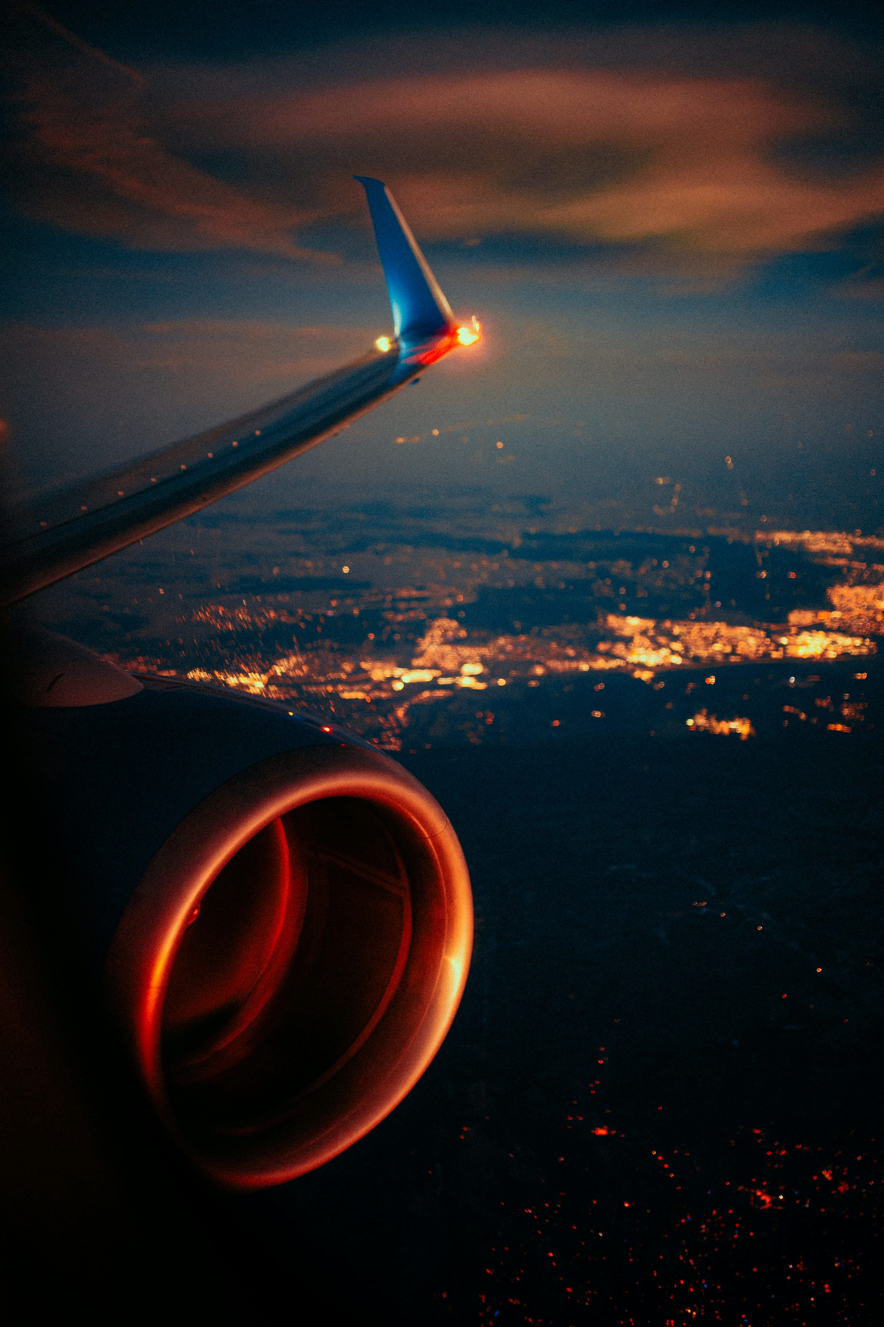 3000x4500 Airplane wing and engine over city lights at night photo