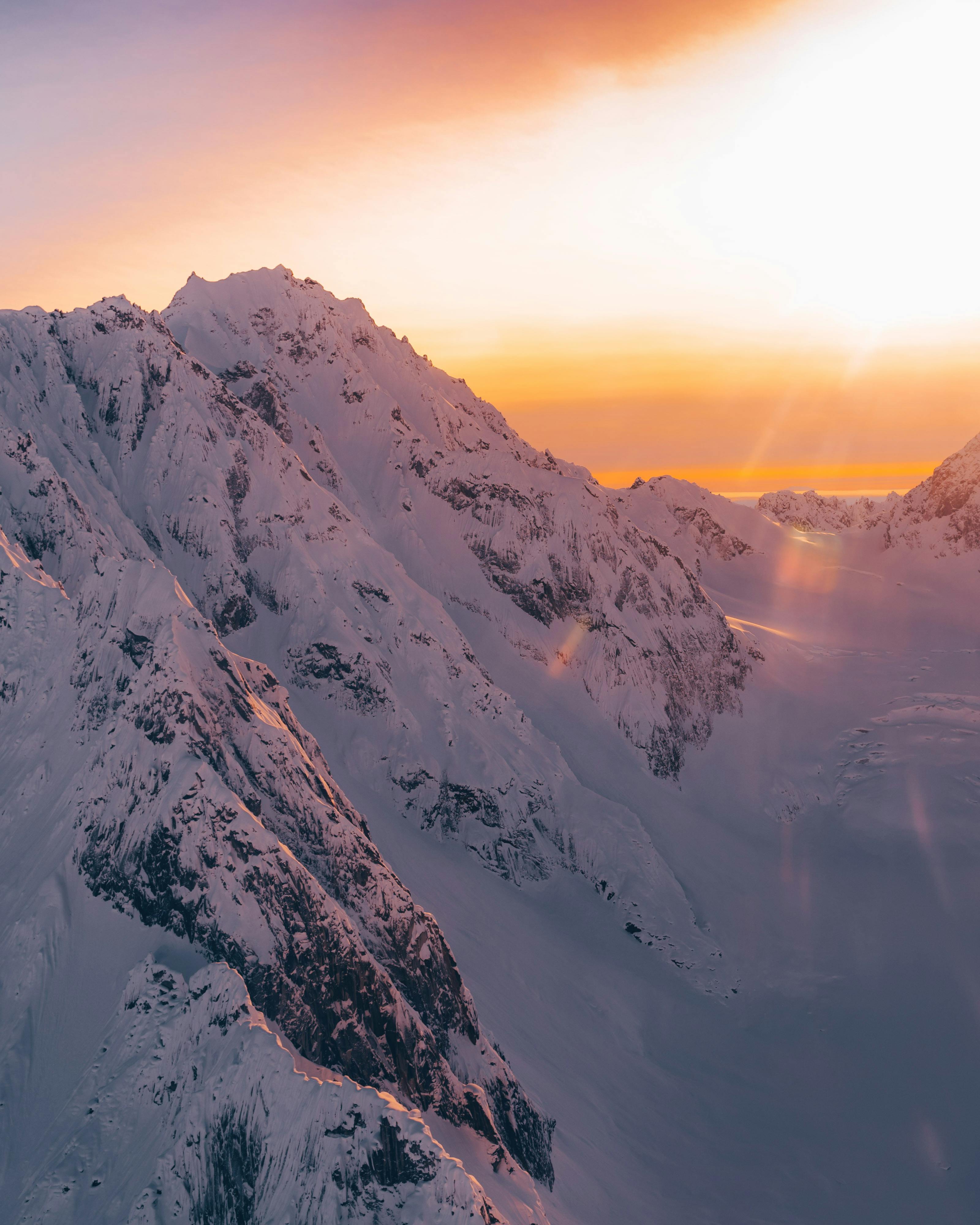 3200x4000 Snowy mountains under bright sunset sky · Free