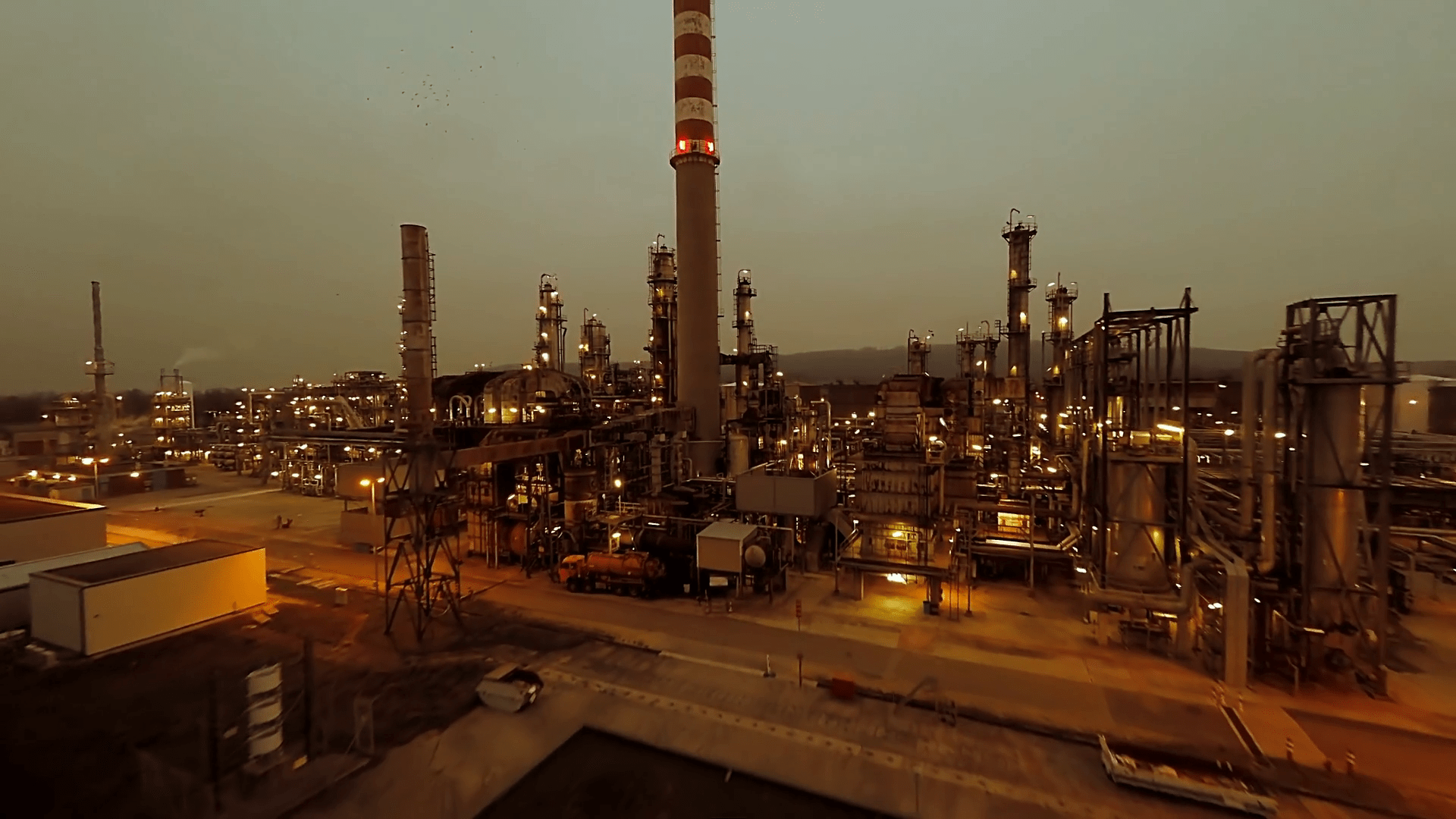 1920x1080 An industrial oil refinery plant scene is captured from an aerial view during twilight