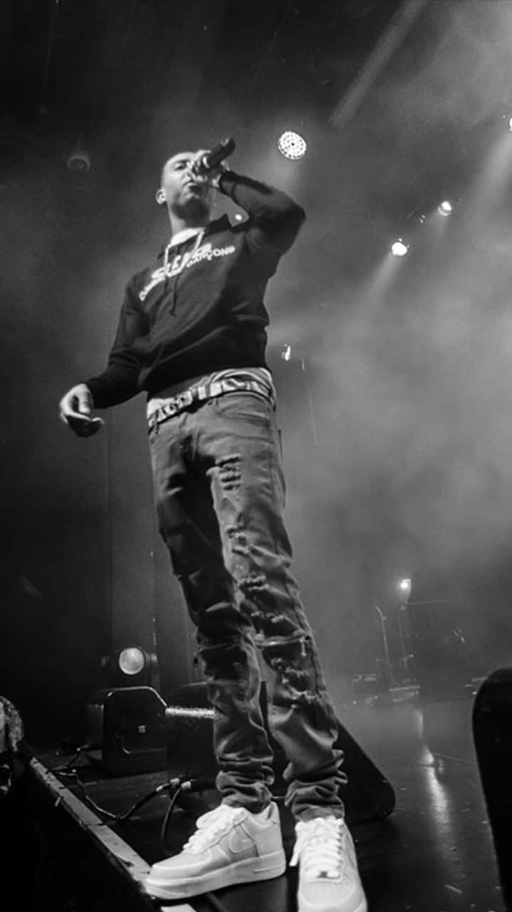 719x1280 Download A Man Standing On Stage With A Microphone Wallpaper