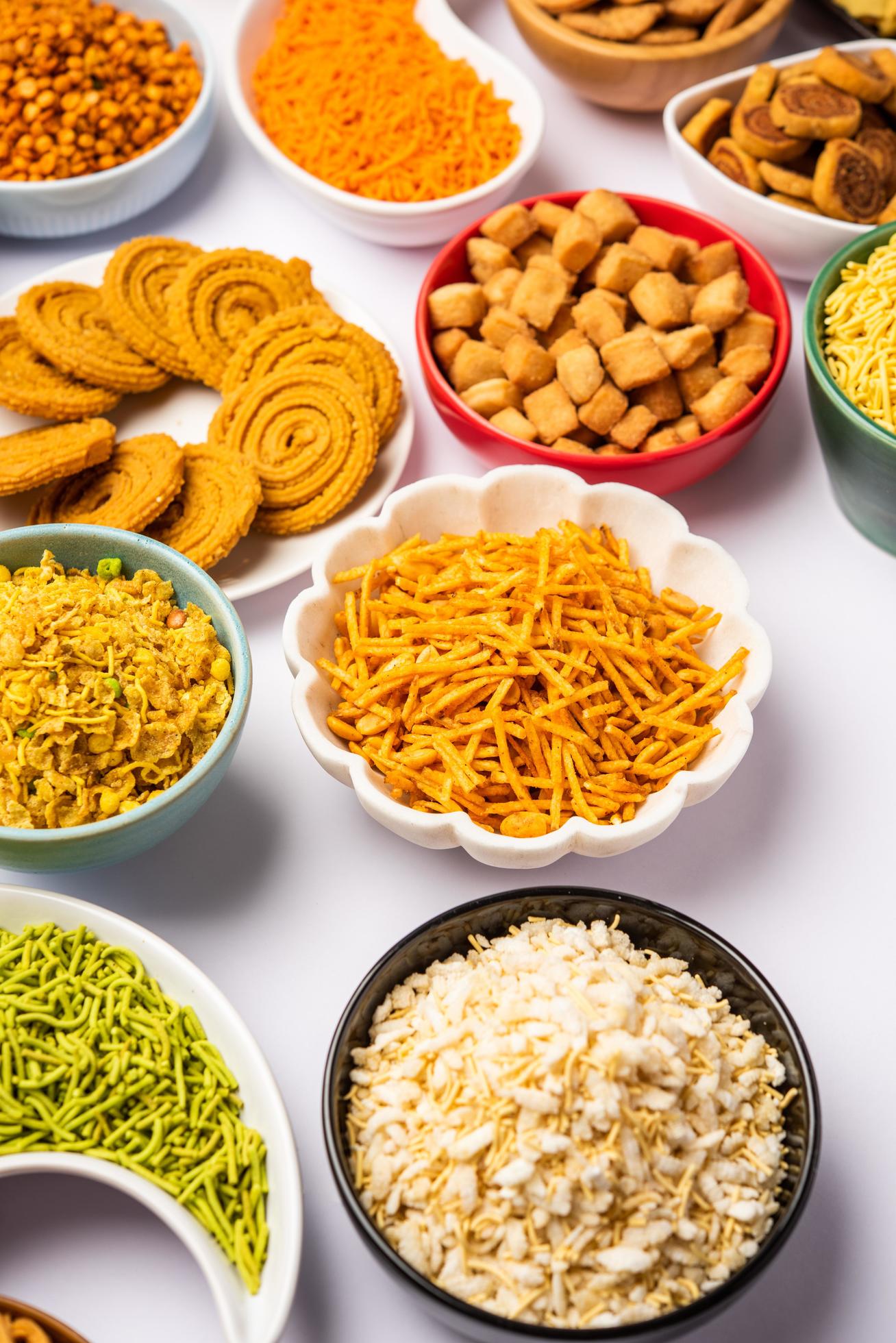 1308x1960 Indian Tea time snacks in group. Sev, chivda, farsan, mixture, bakarwadi served in different bowls