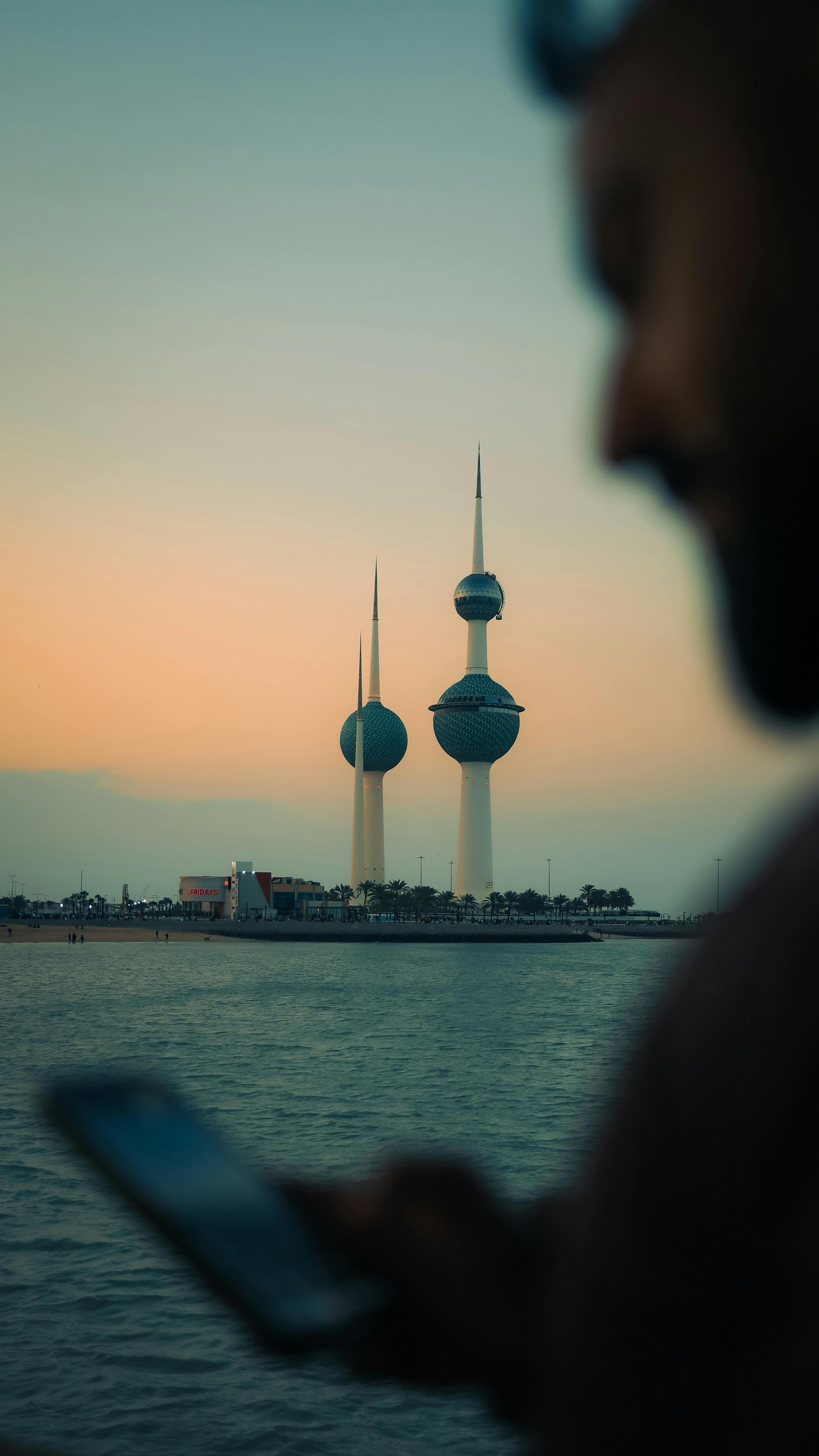 3422x6084 Kuwait Towers behind Man with Smartphone · Free