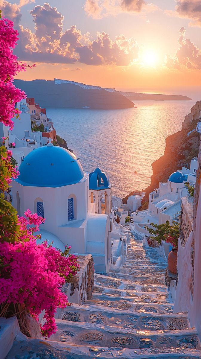 673x1200 A view of Santorini at sunset. Whitewashed buildings with blue domes perched on the cliffs