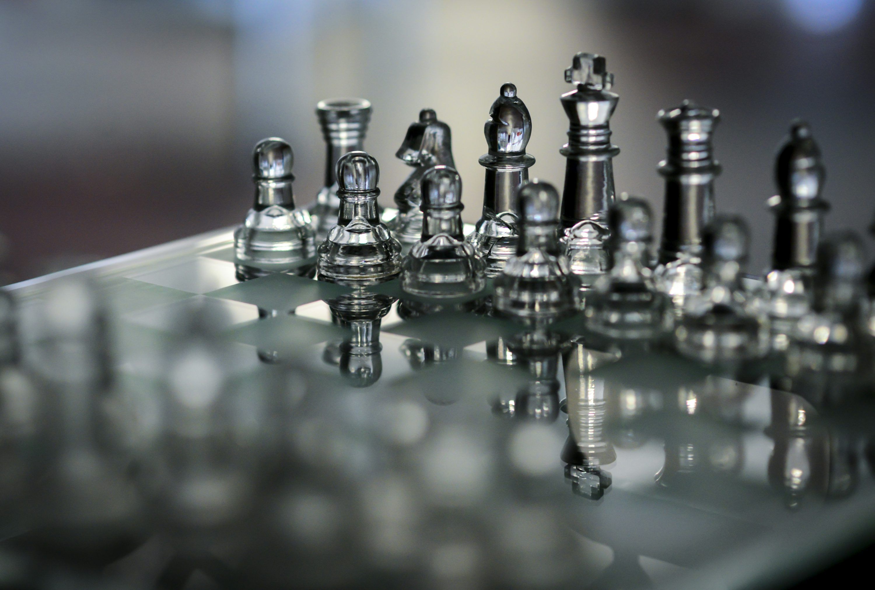 3000x2022 A glass chess board with silver chess pieces photo