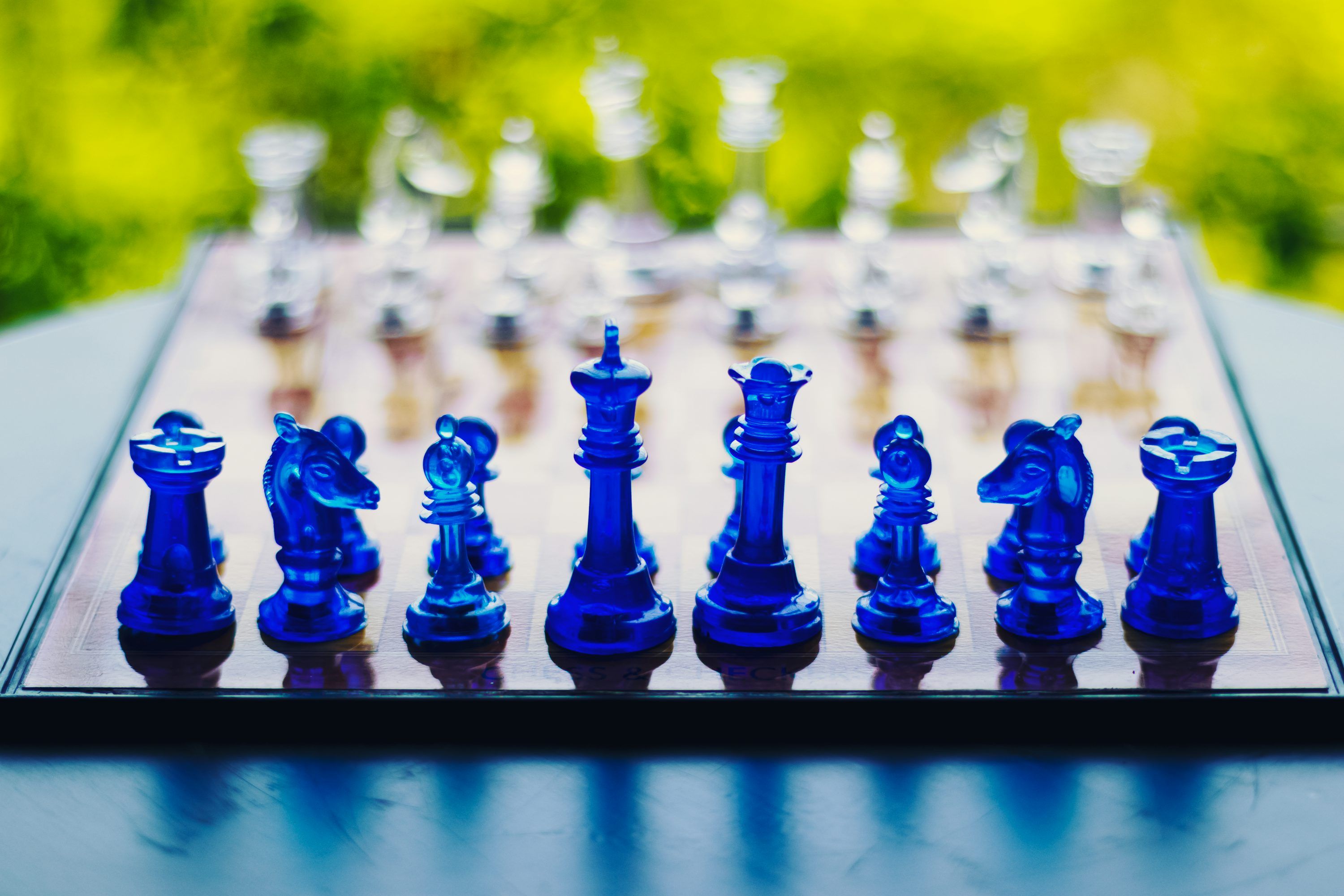 3000x2000 A glass chess set with a blurry background photo