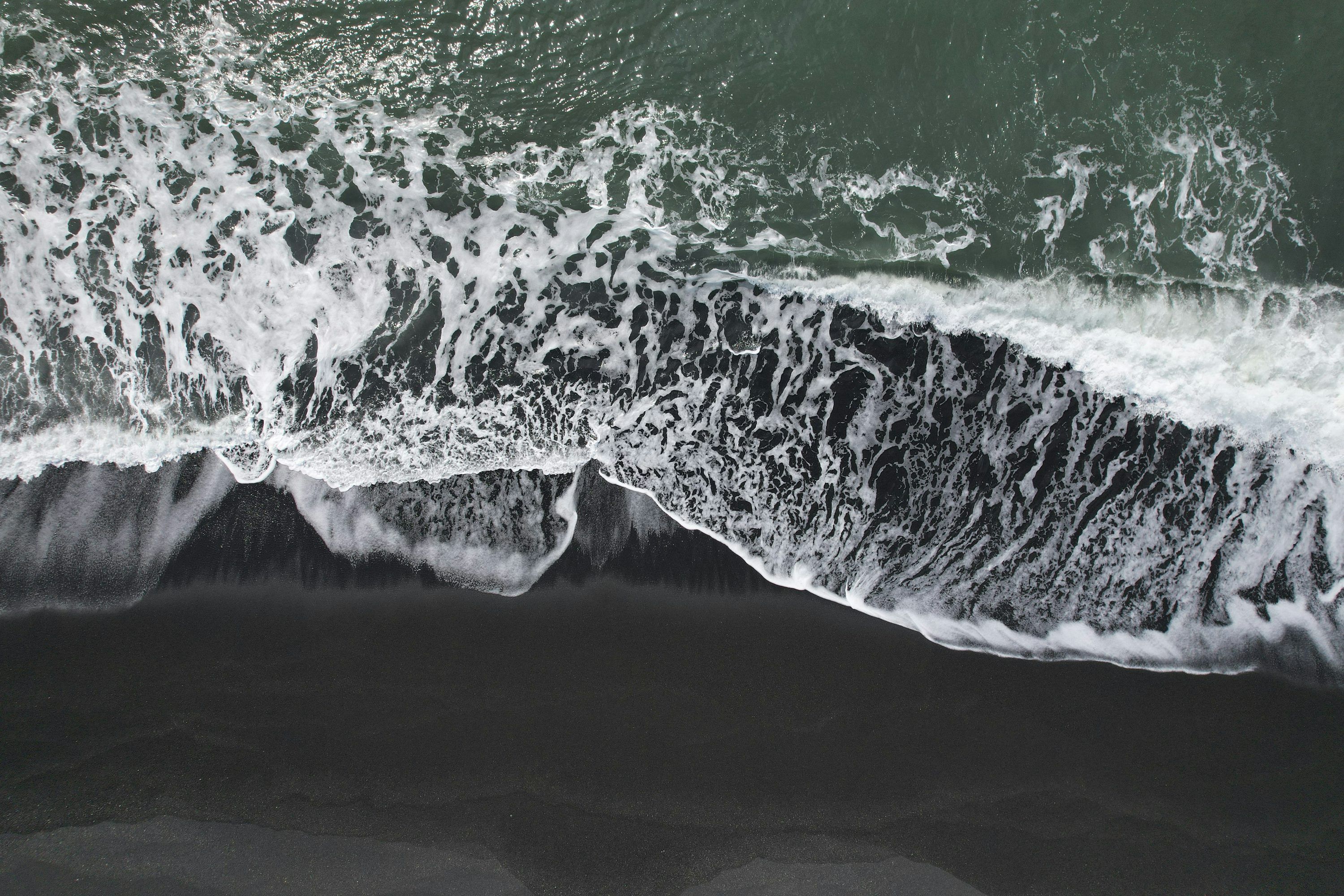 3000x2000 An aerial view of a black sand beach photo