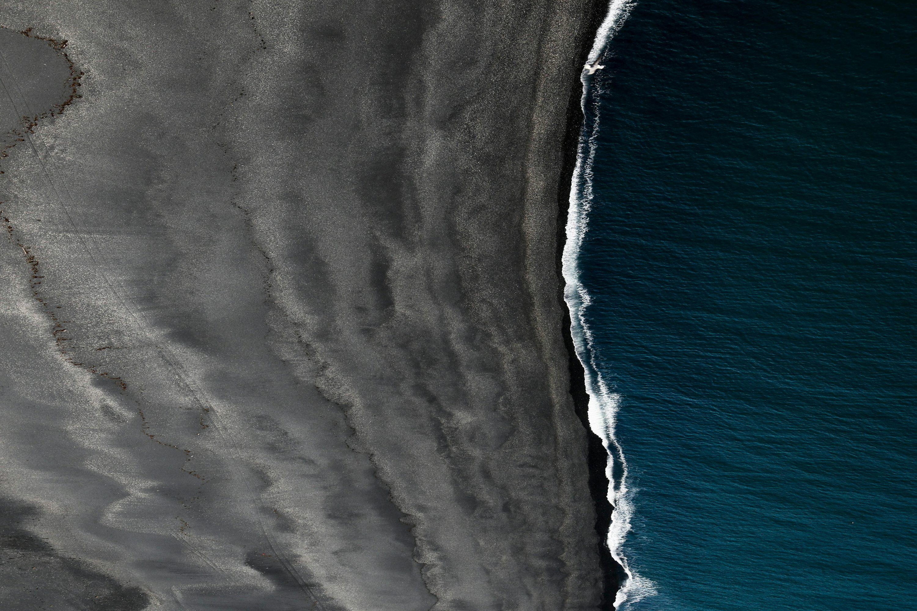 3000x2000 Bird's view of black sand and body of water photo
