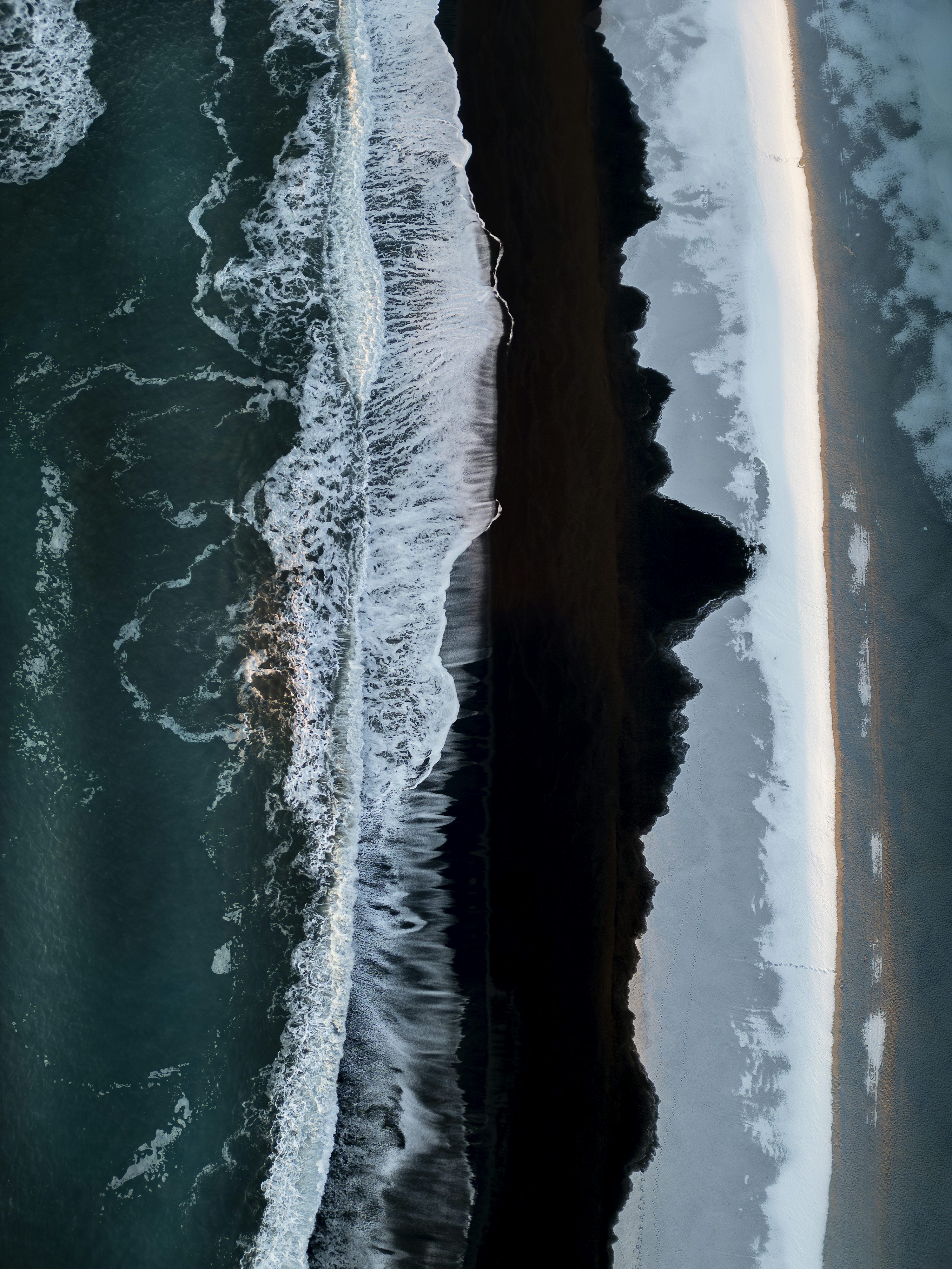 3000x4000 Aerial view of waves crashing on a black sand beach photo