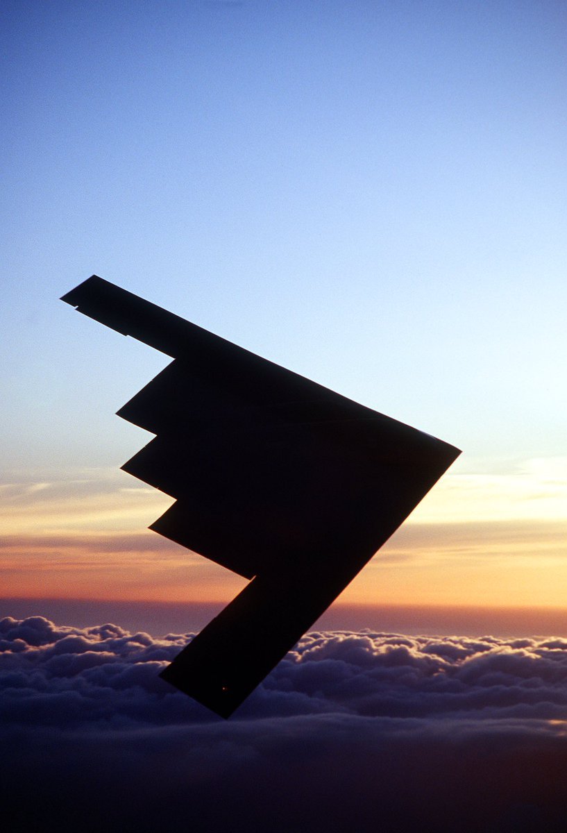 817x1200 Air To Air View Of A Silhouetted, Northrop Built B 2 Spirit Bomber Flying A Training Sortie At Sunset Near The Base. The B 2 Is Assigned To Air Combat Command, 8th Air Force's 509th