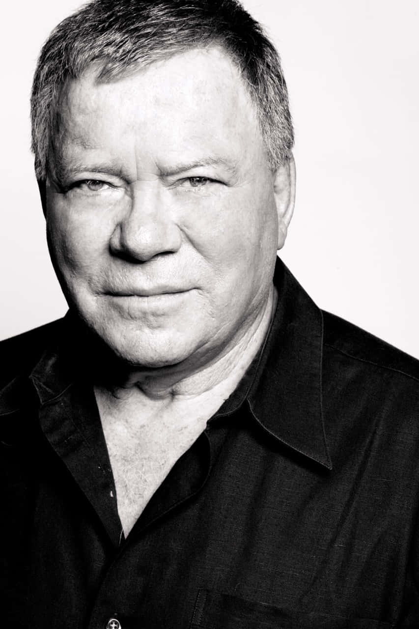 853x1280 Download William Shatner striking a pose in a black suit and tie Wallpaper