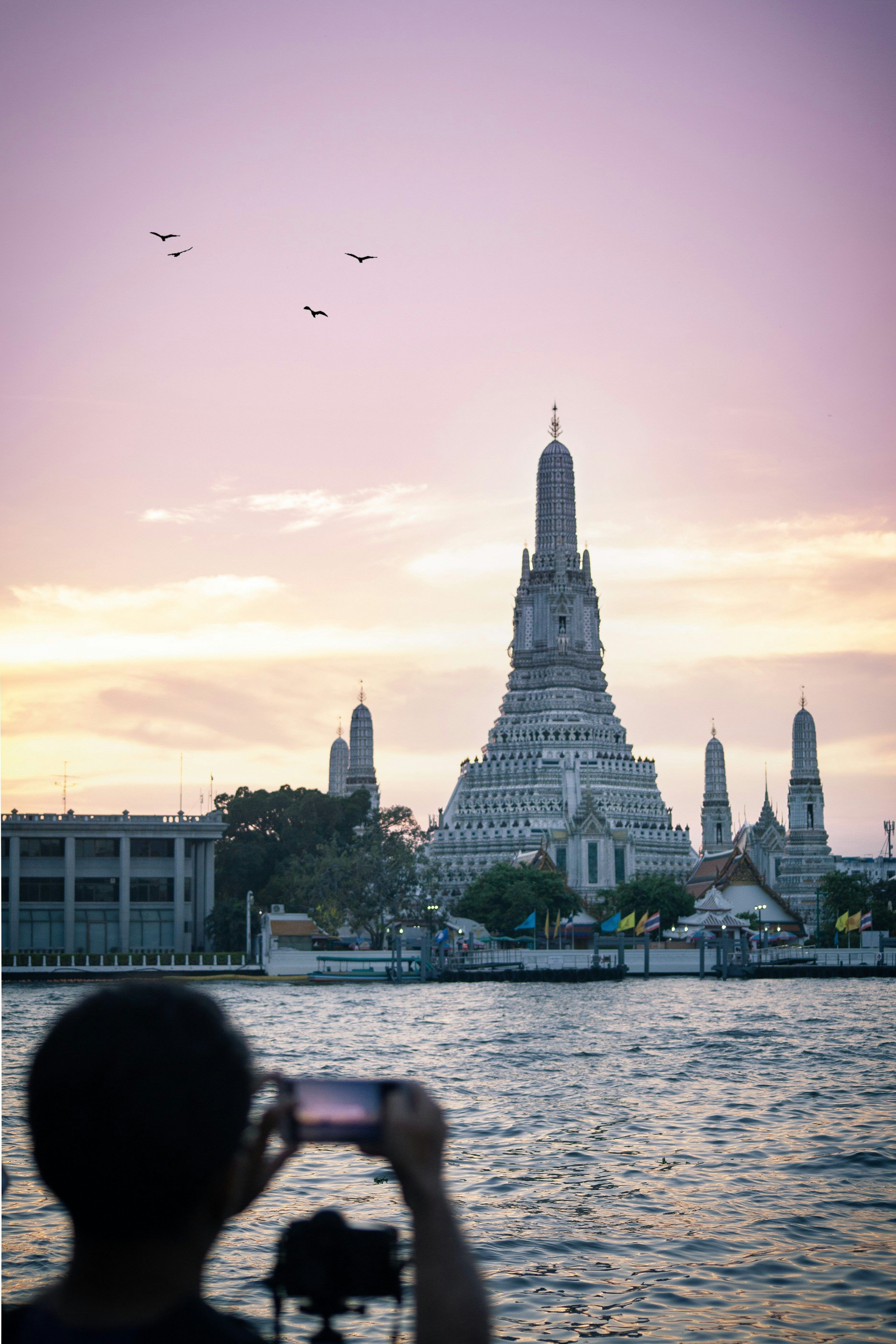 3000x4500 A large building with pointy towers by a body of water with Wat Arun in the background photo