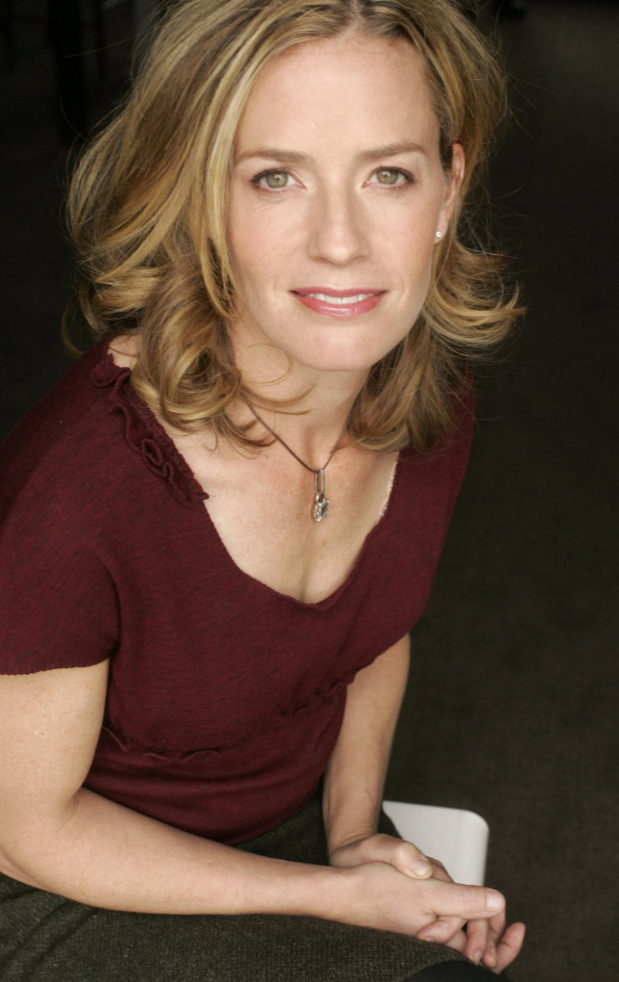 1211x1920 Download Elisabeth Shue Wearing Maroon Top With Both Hands On Lap Smiling Wallpaper