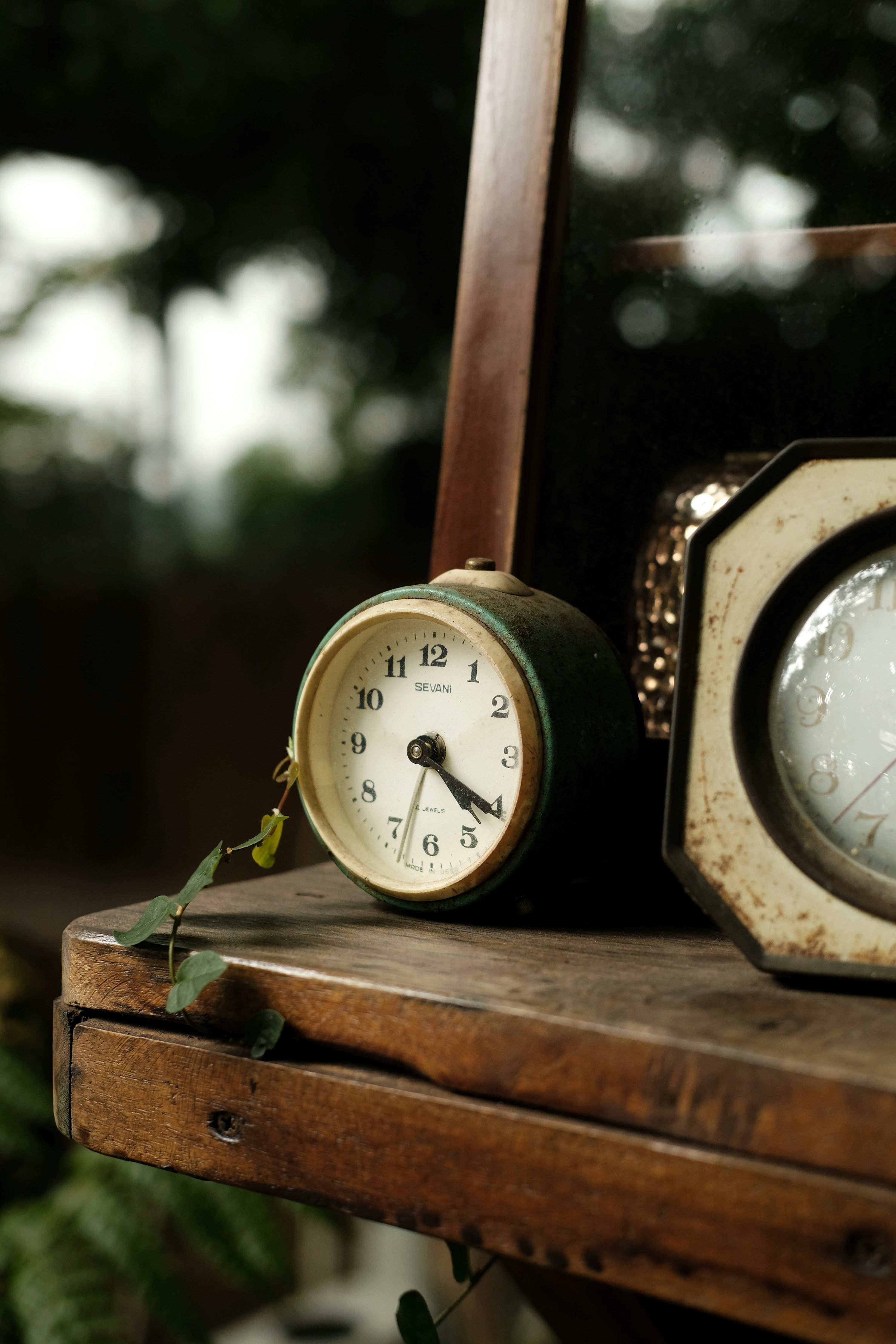 3000x4500 A couple of clocks sitting on top of a wooden table photo