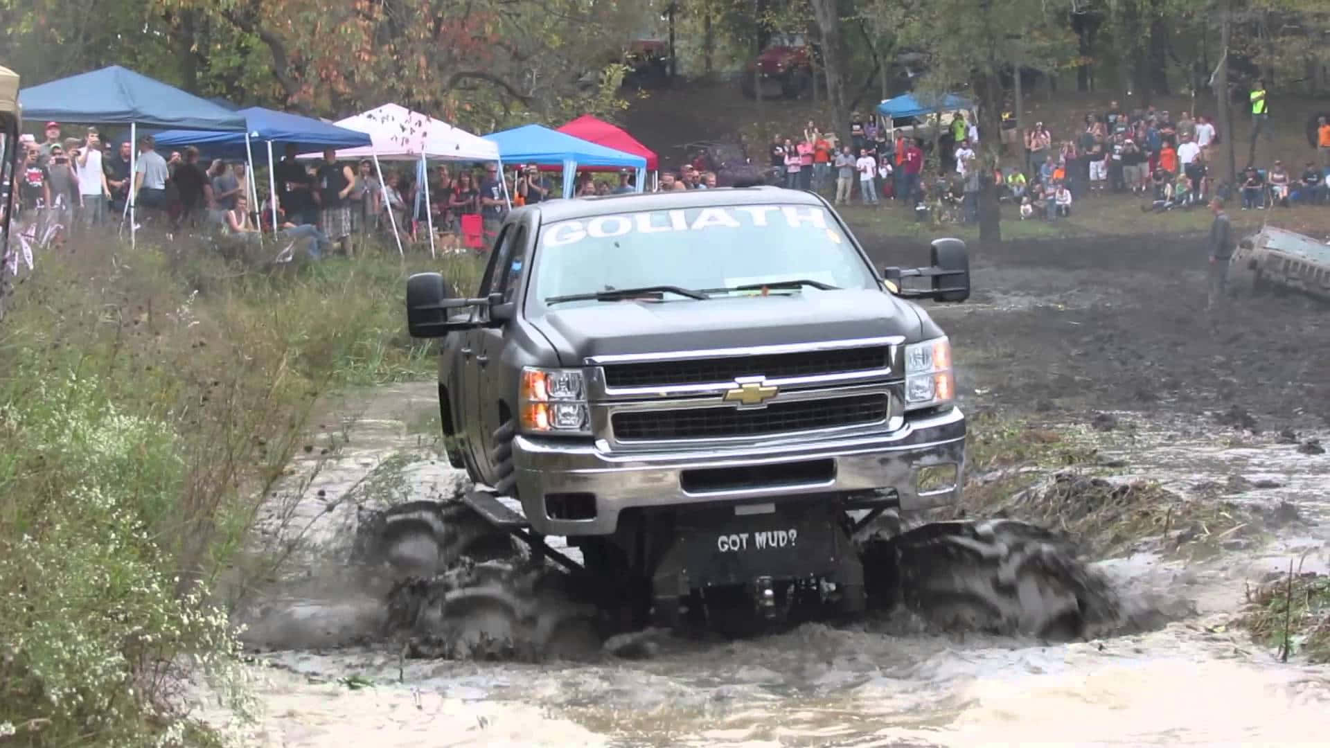 1920x1080 Download A Truck Driving Through Mud At A Festival Wallpaper