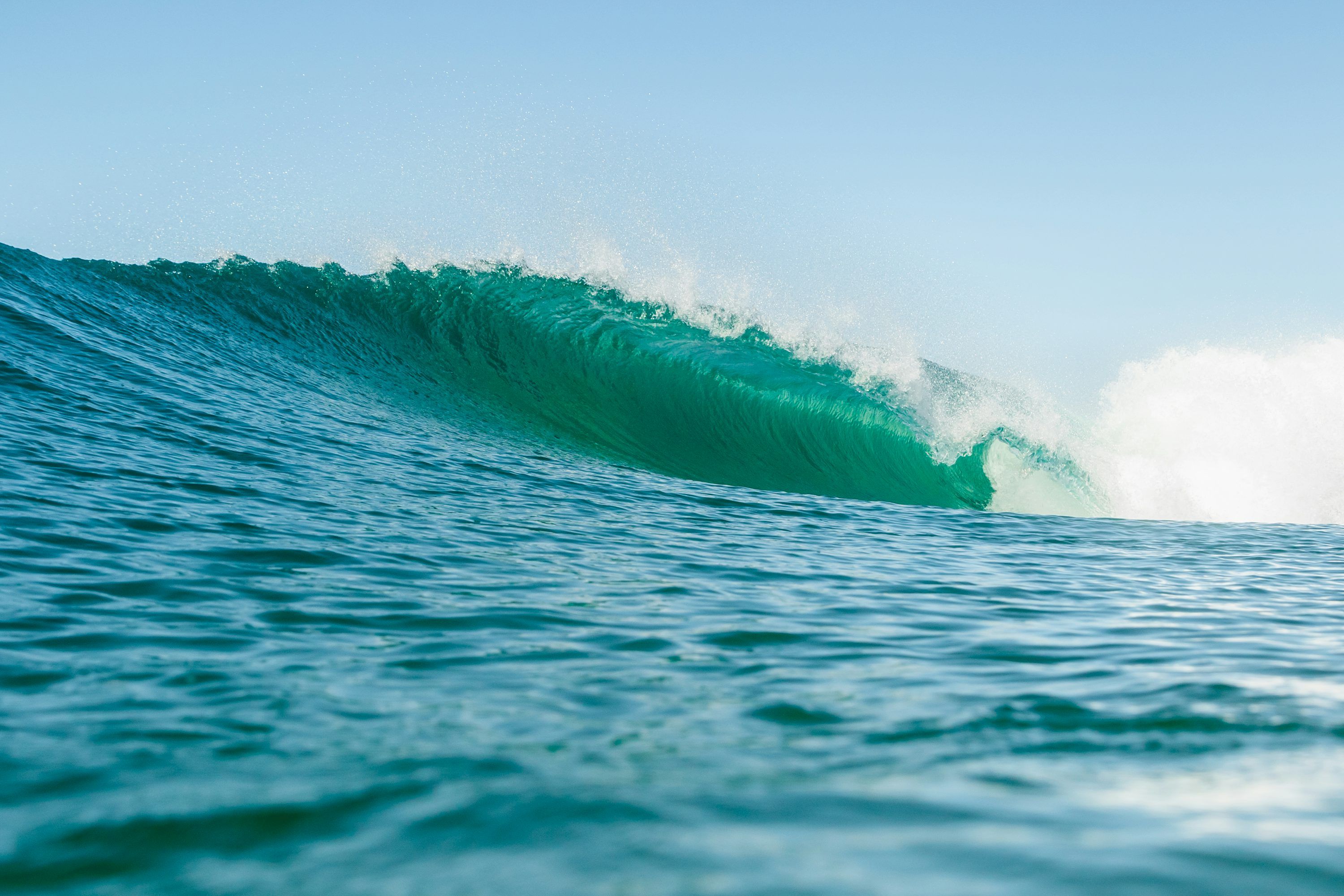 3000x2000 A large green wave in the middle of the ocean photo