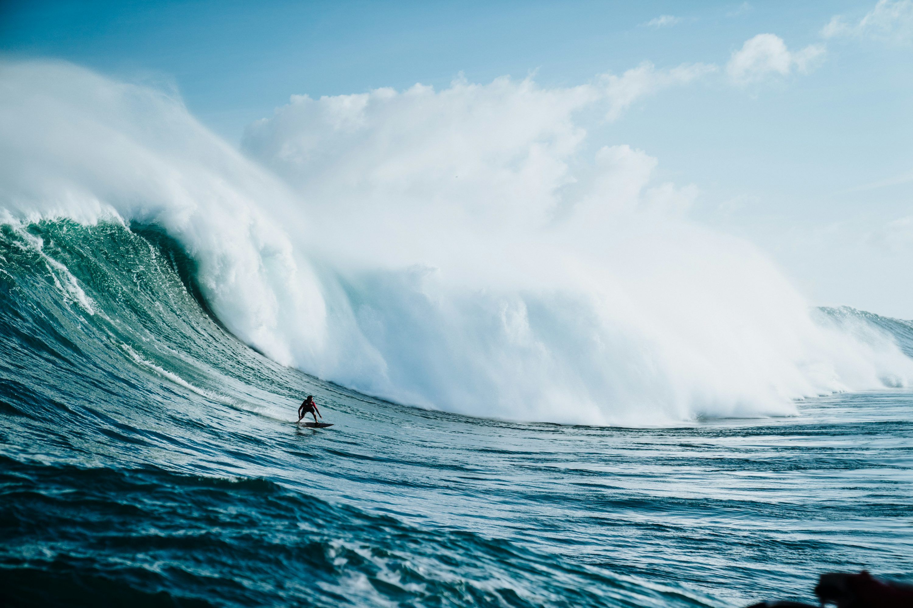 3000x2000 Person riding on surfboard with waves behind photo