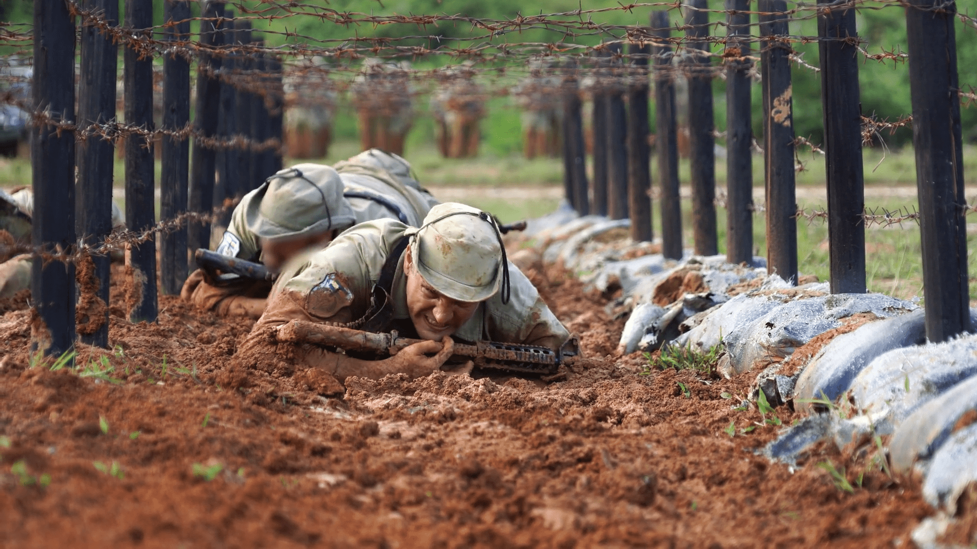 1920x1080 Soldier training crawling with rifle. Marine unit navigating obstacle course for elite training in muddy crawling path with equipment