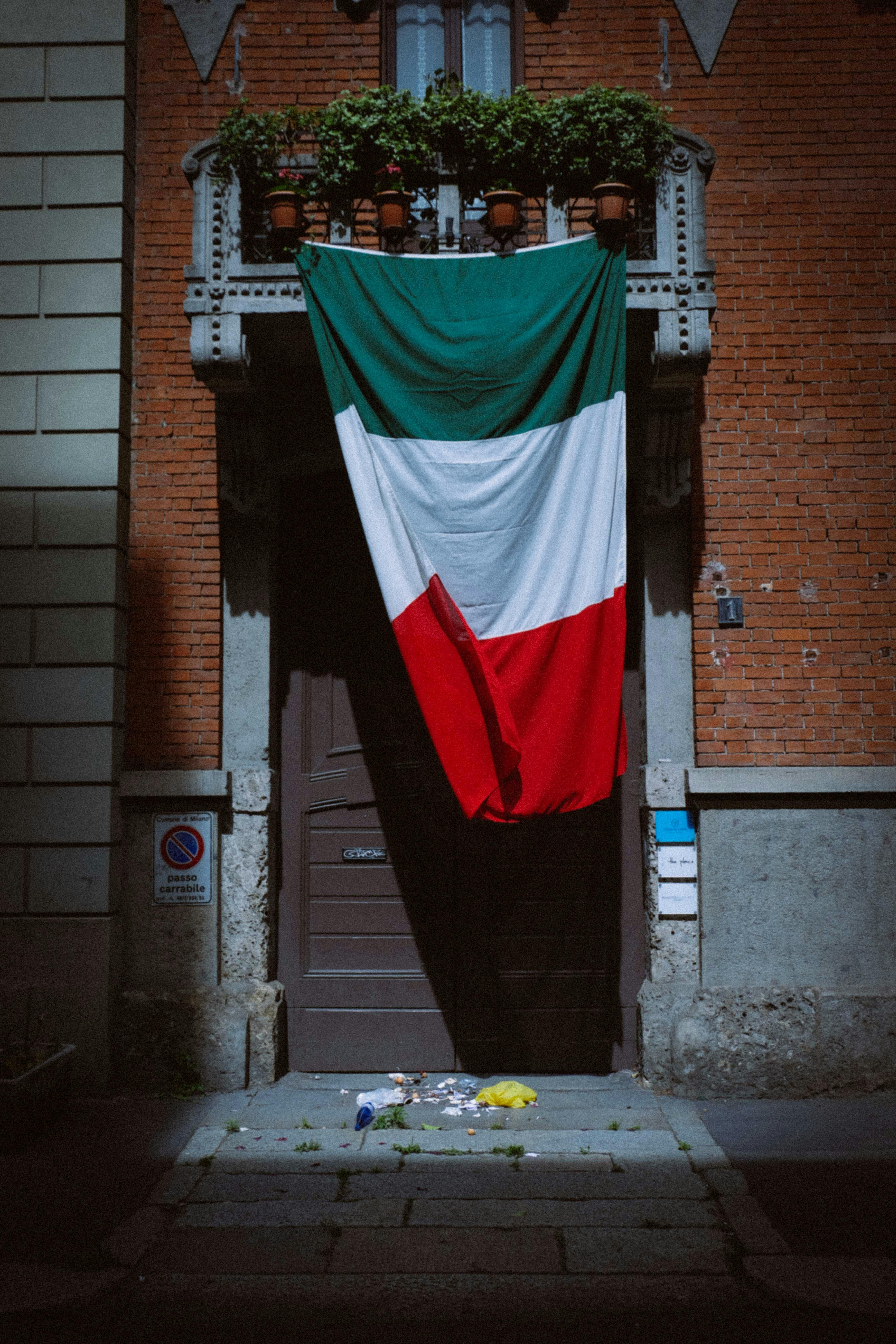 3967x5950 Italian flag hanging on entrance of brick house · Free
