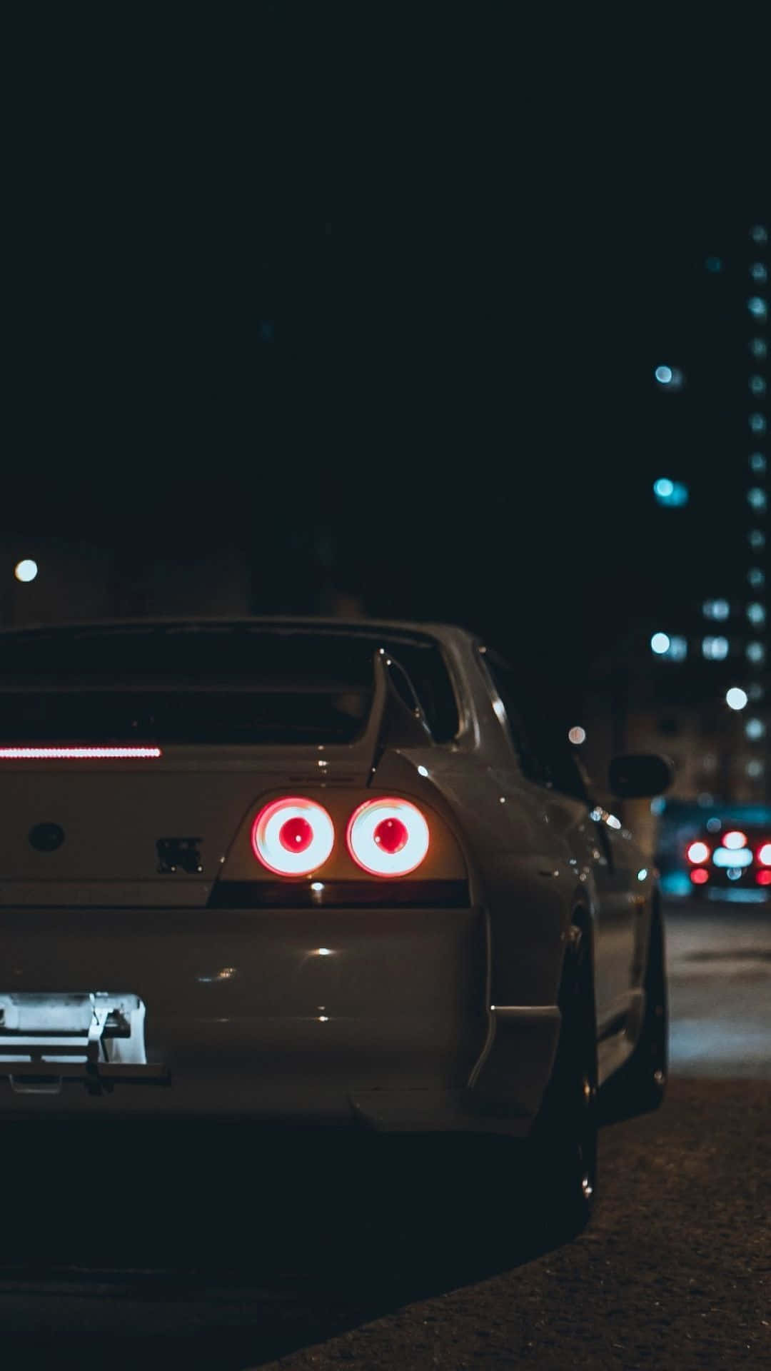 1080x1920 Download A White Car With Red Lights On The Road At Night Wallpaper