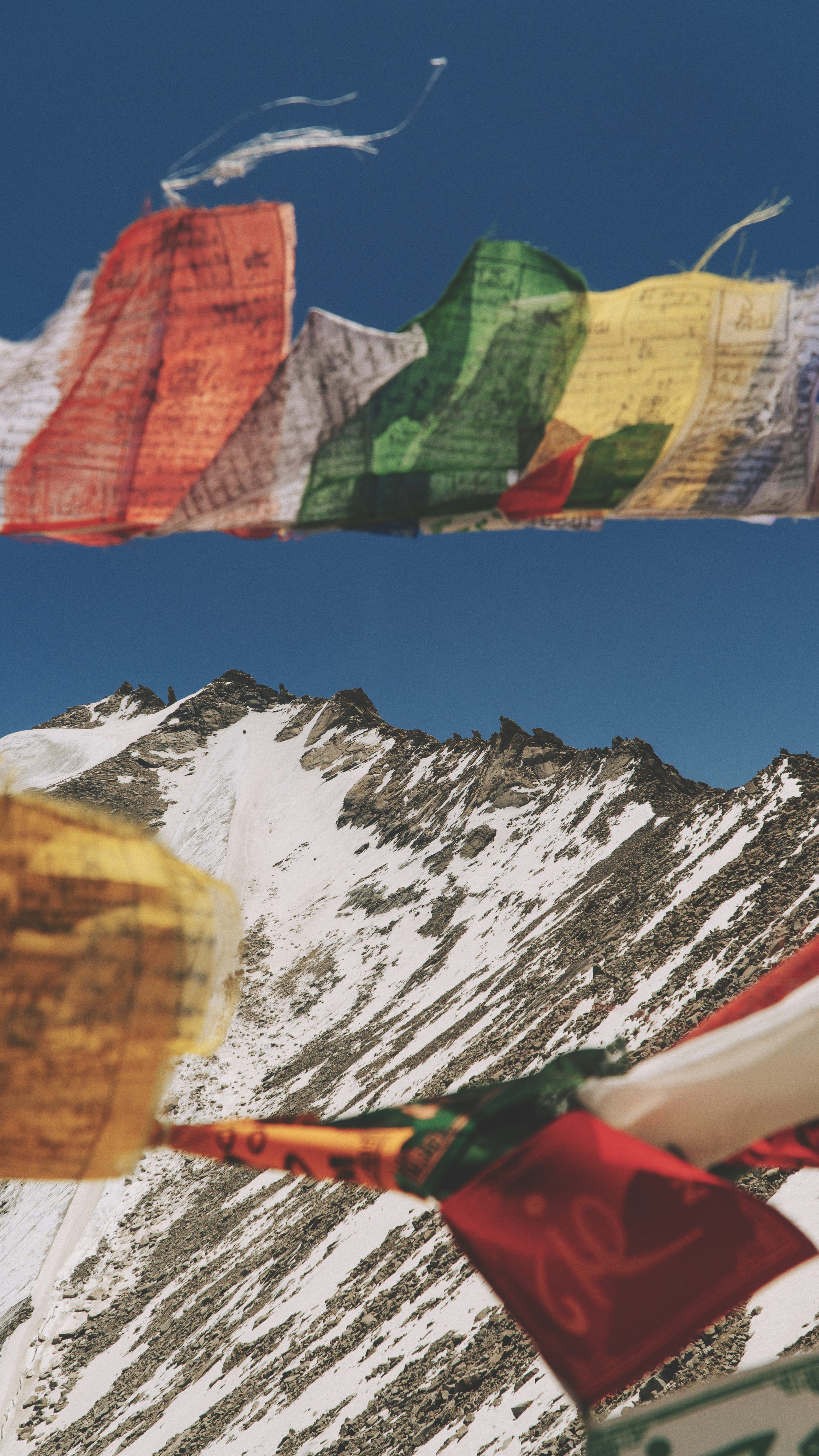 3000x5332 Prayer flags flutter above a snowy mountain. photo